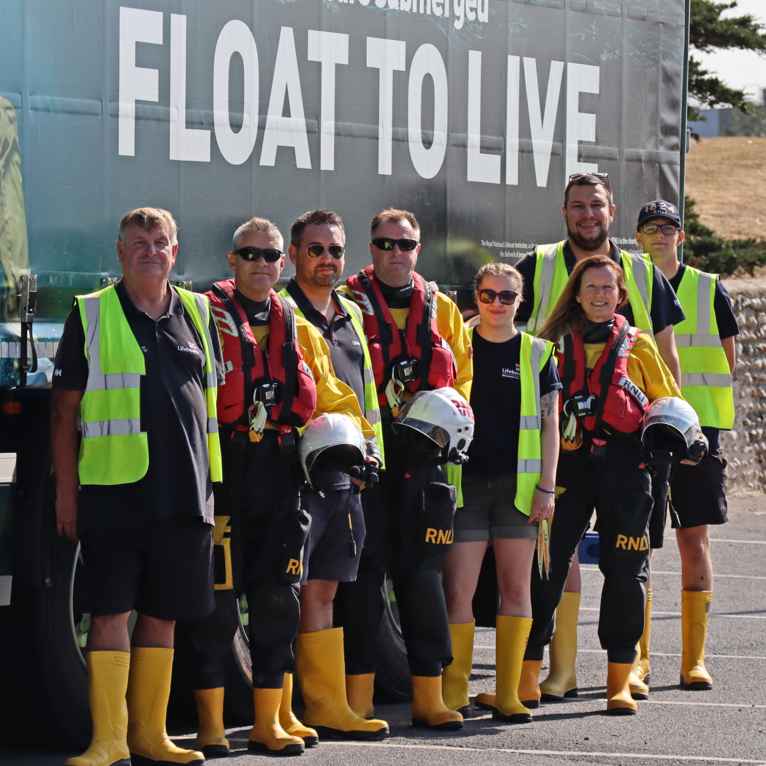 Eight volunteers from Littlehampton RNLI in full kit line up alongside the Scania/RNLI truck