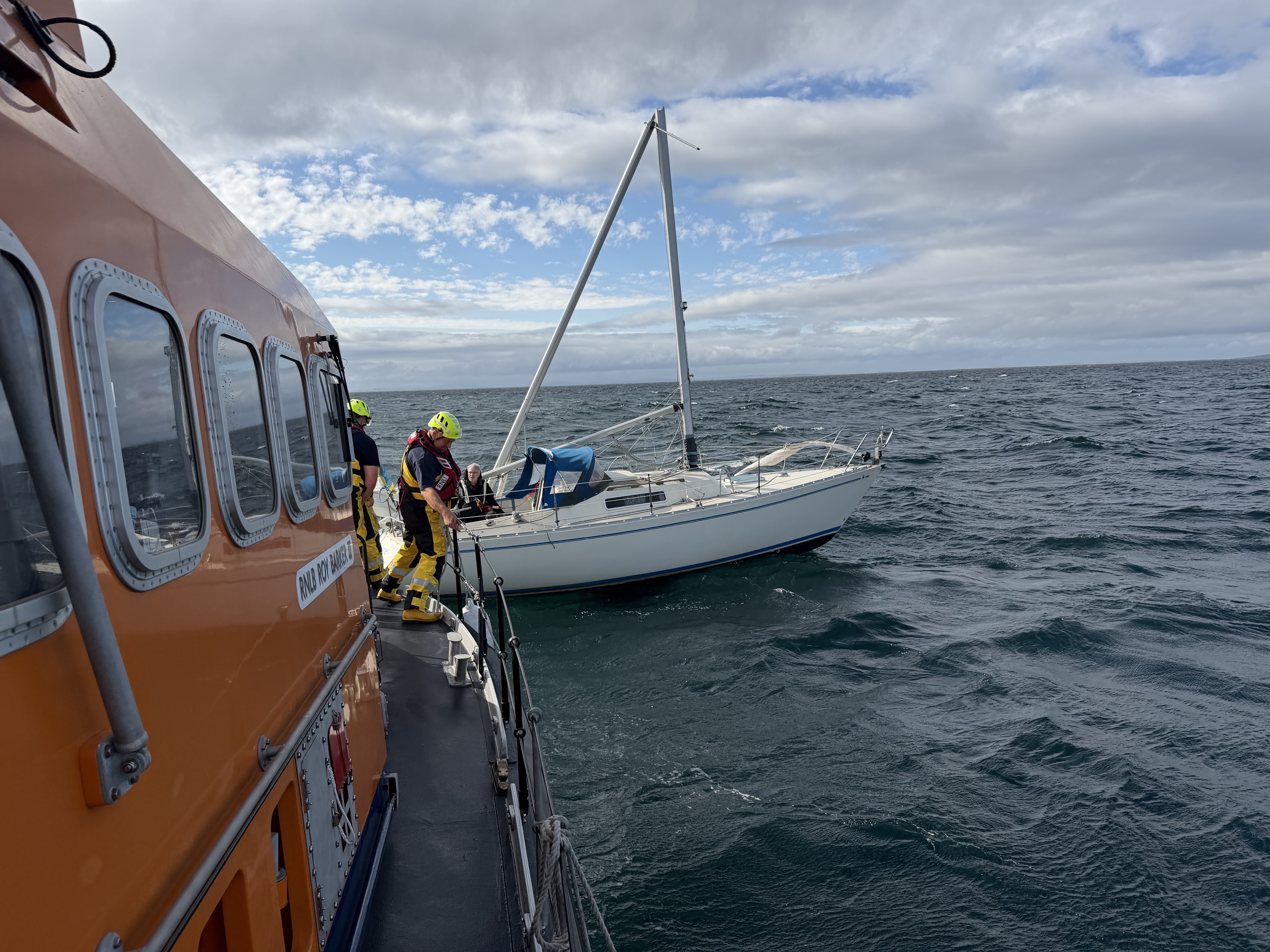 Wick RNLI's all-weather lifeboat Roy Barker II escorted a dismasted yacht safely to Wick after a lengthy offshore rescue.
