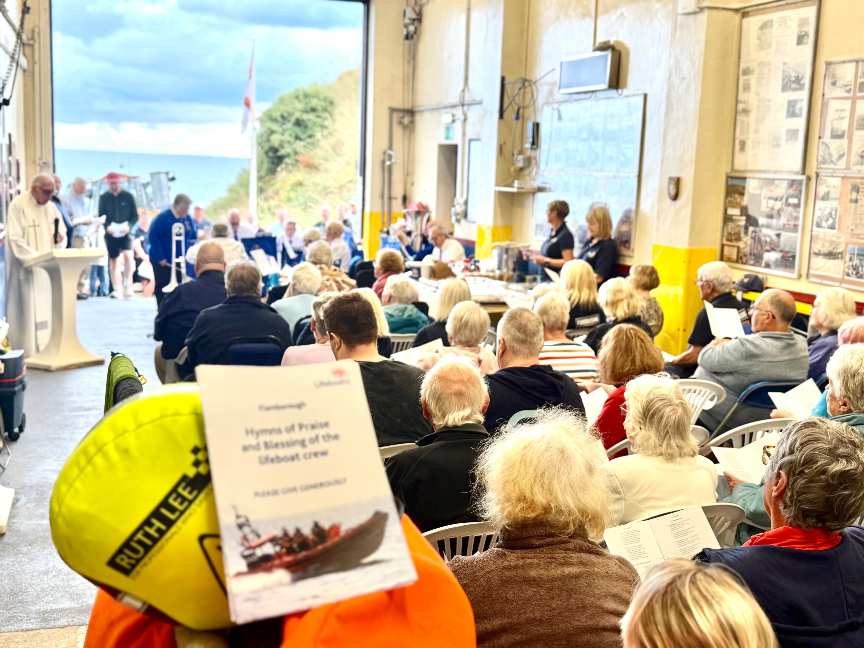 crew members friends family and supporters gather for the service in the boathouse