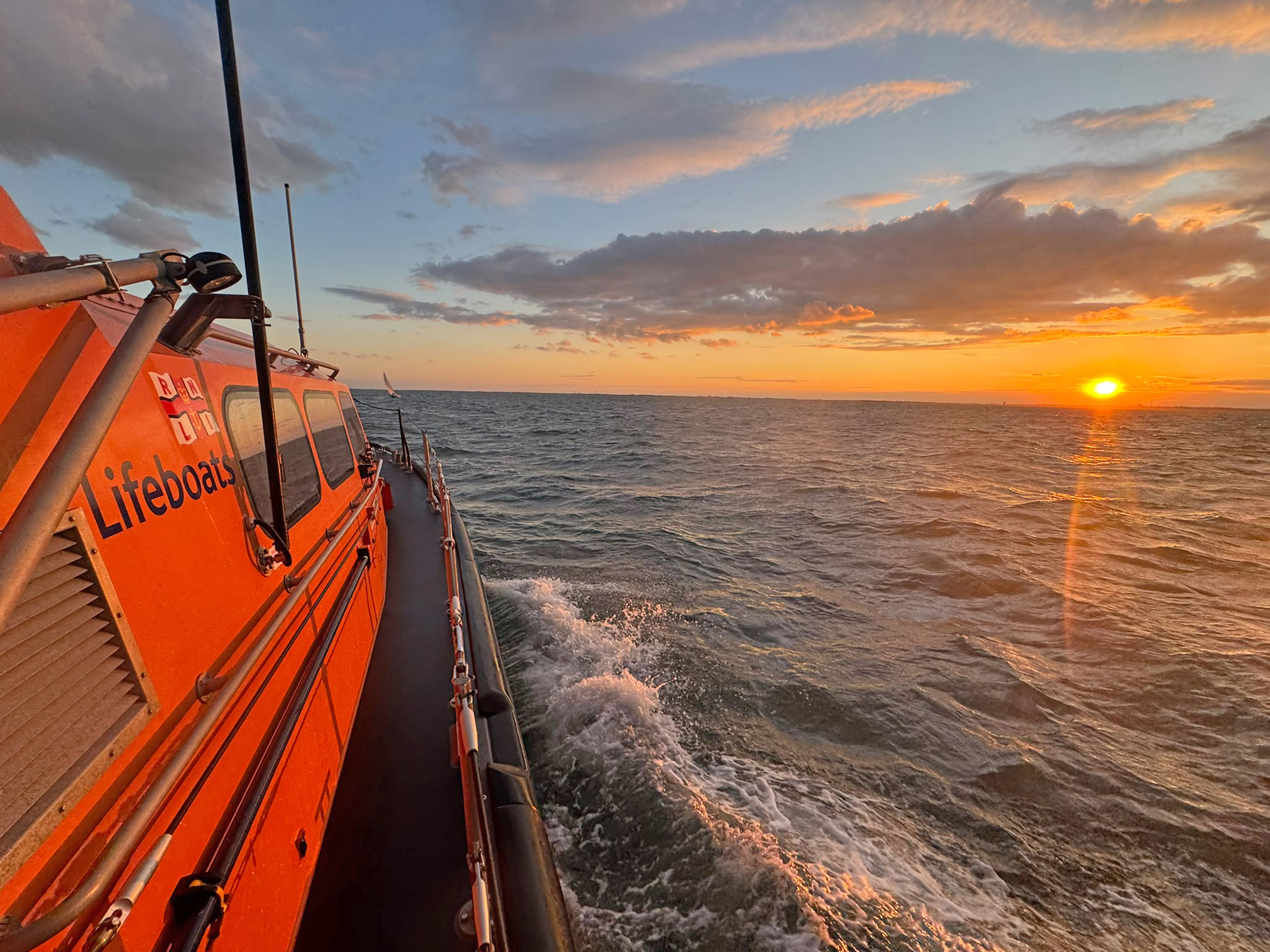 Lowestoft Lifeboat Patsy Knight escorting the yacht at sunset