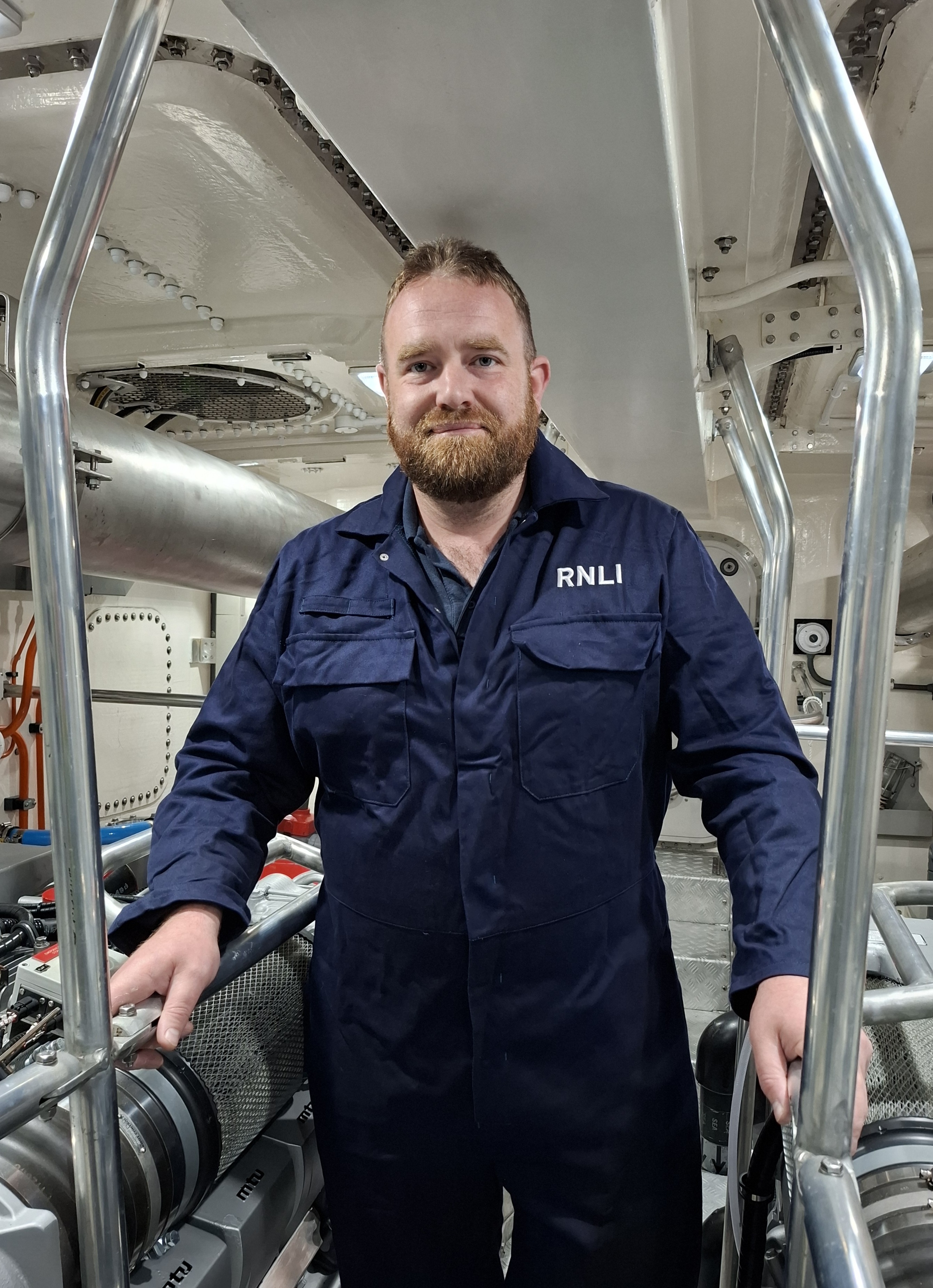 Lifeboat crew member in overalls in lifeboat engine room