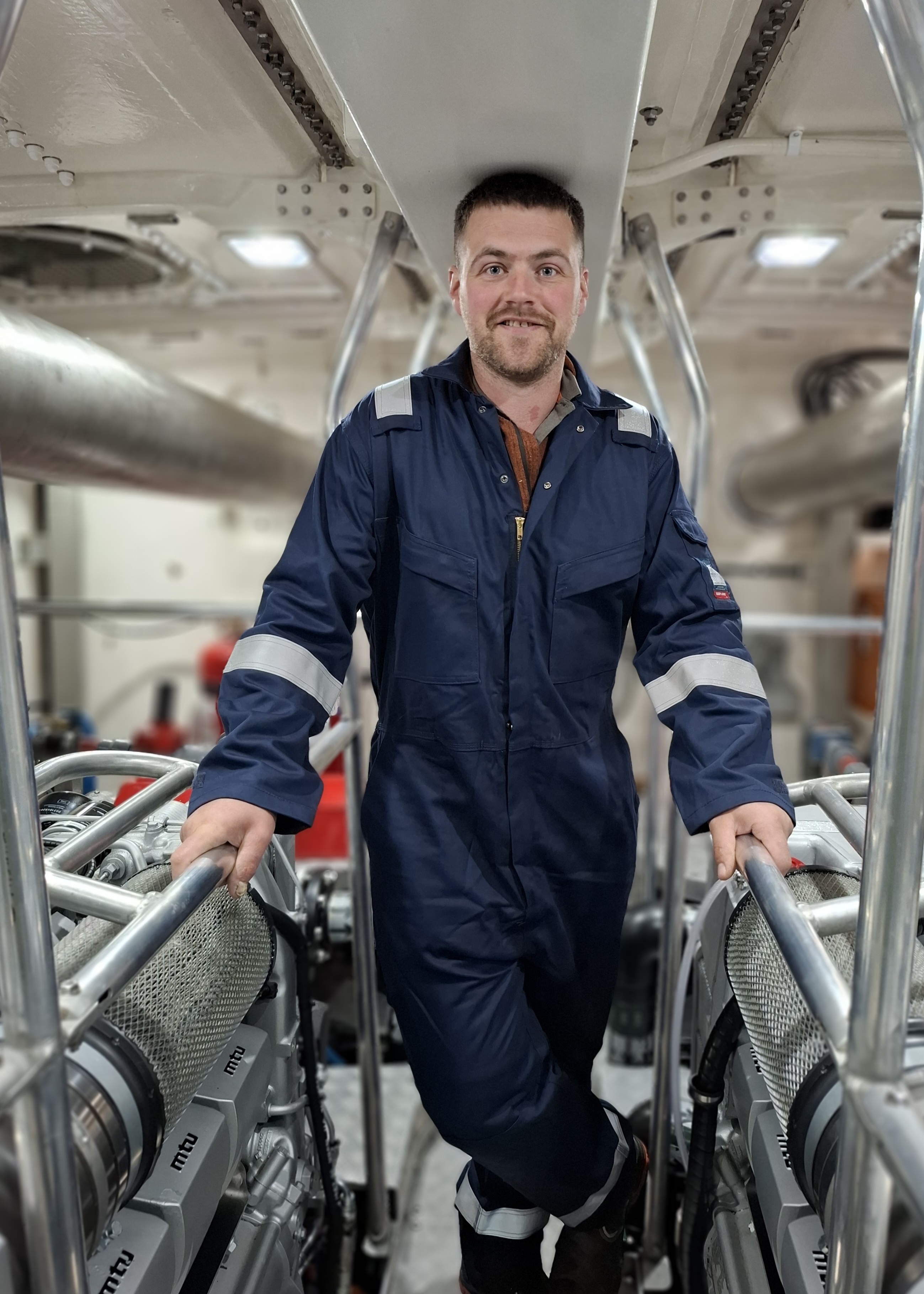 Lifeboat crew member in overalls in lifeboat engine room
