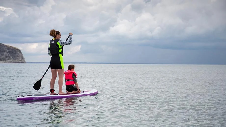 Woman and child on a paddleboard.