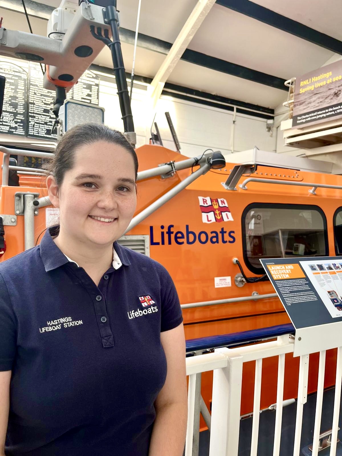 RNLI volunteer standing in front of lifeboat