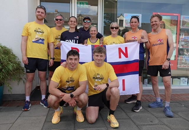 People in lifeboat t-shirts with the brothers and an RNLI flag