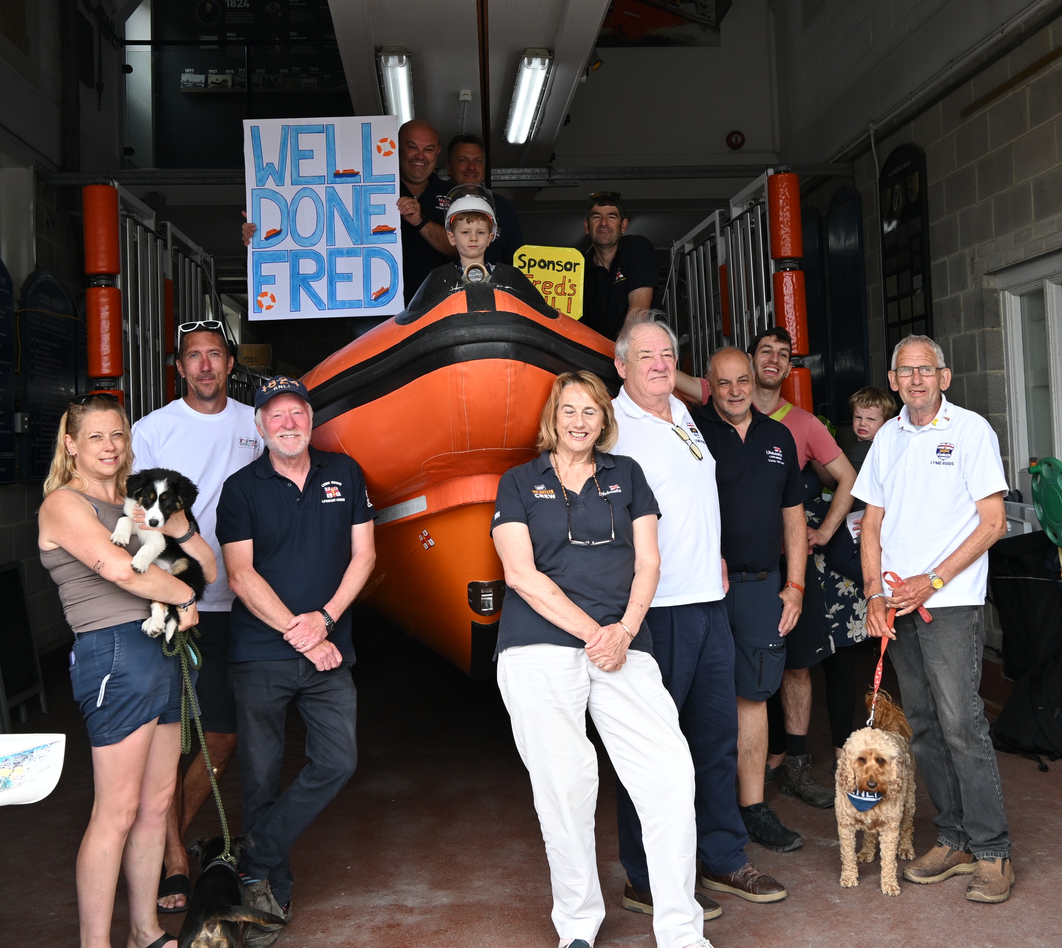 Group of RNLI volunteers in front of orange lifeboat