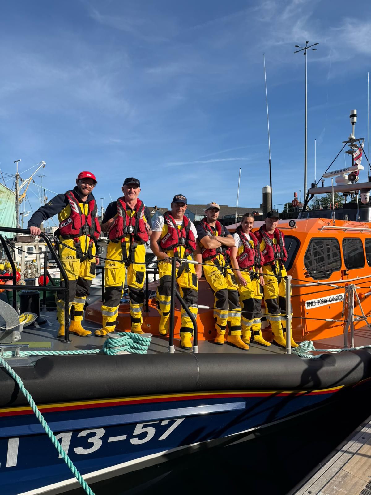 Crew involved in the rescue standing on the Kilkeel Shannon lifeboat port side.