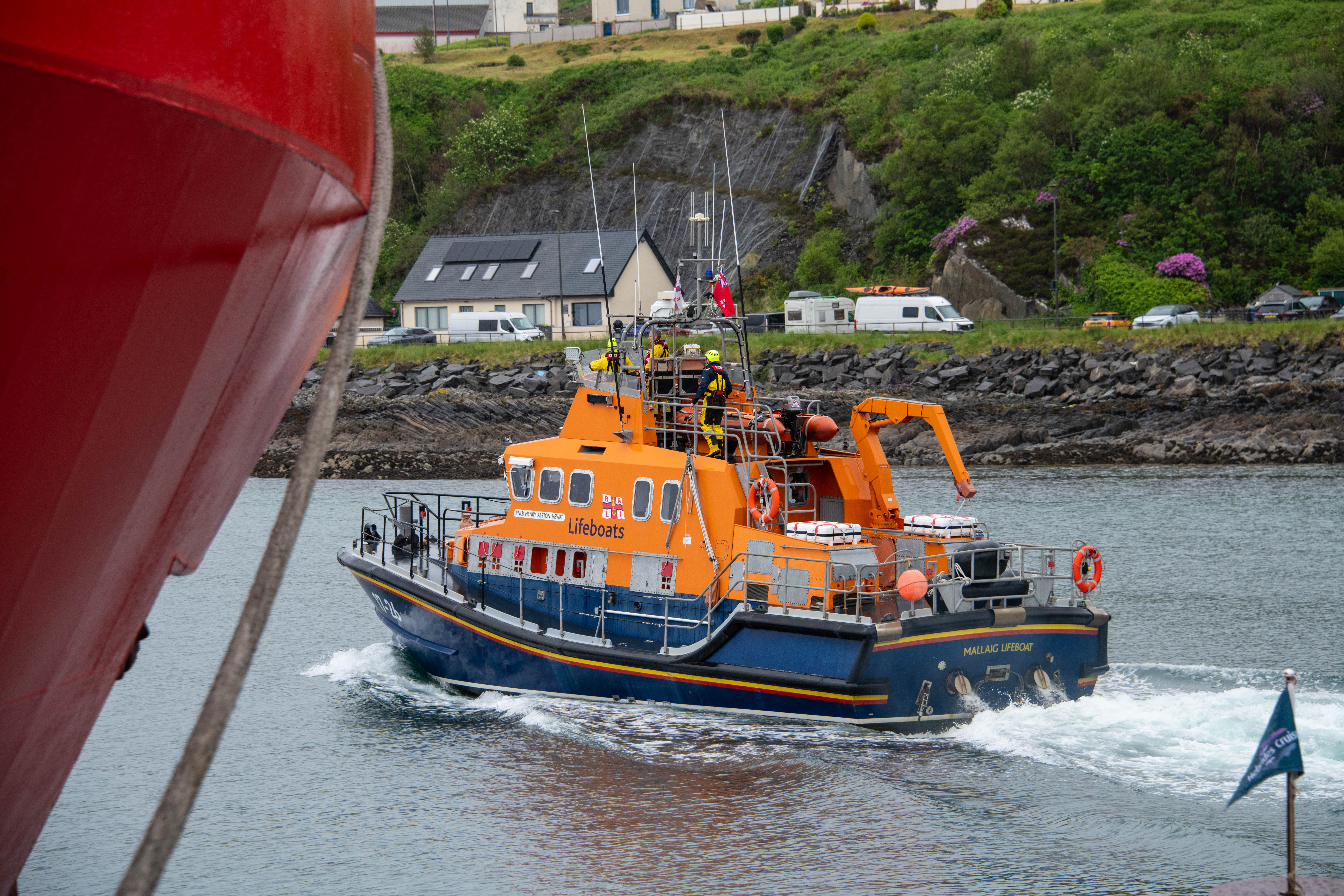 Mallaig RNLI Lifeboat on the water, heading out of harbour to shout