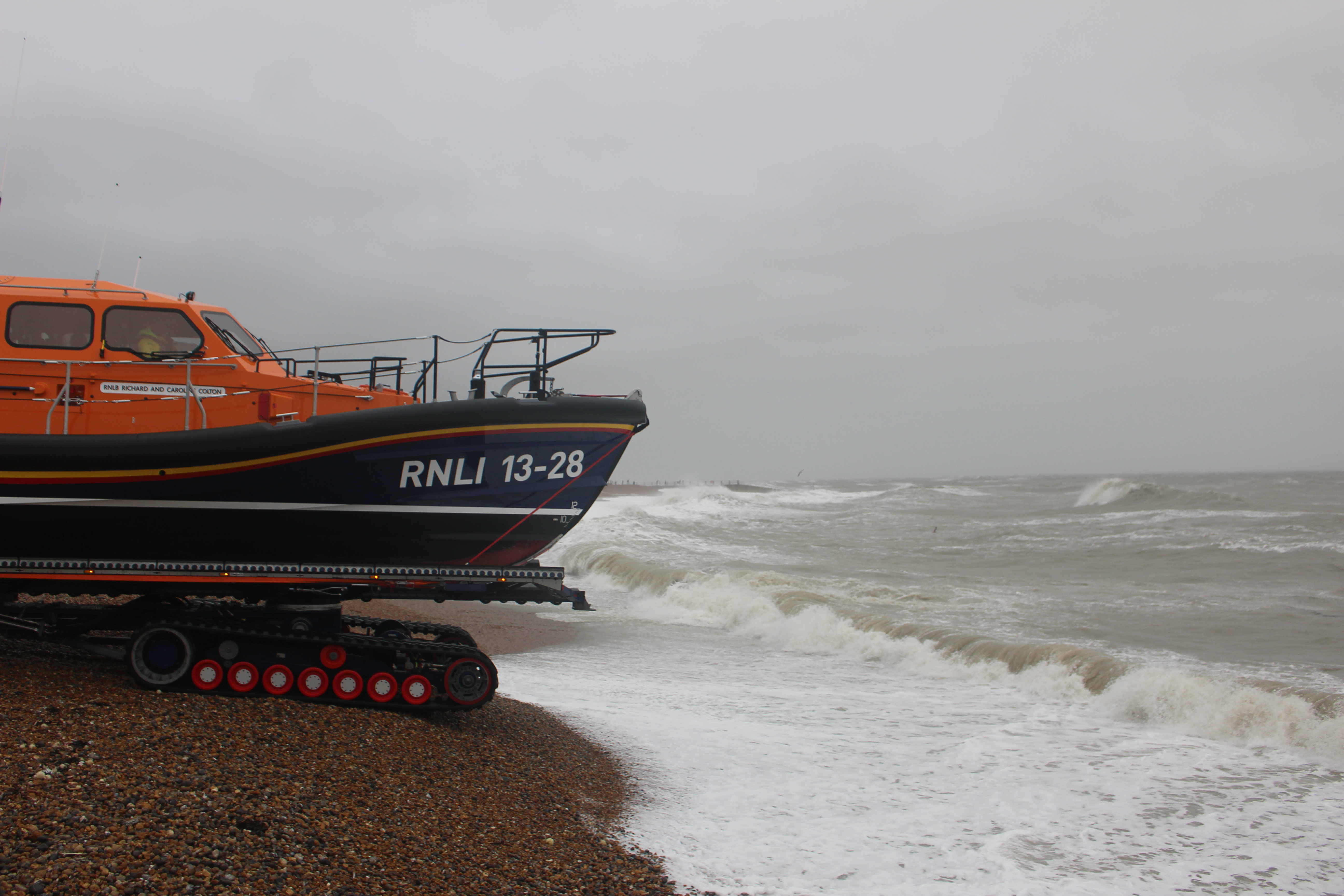A lifeboat at the water's edge with a rough sea