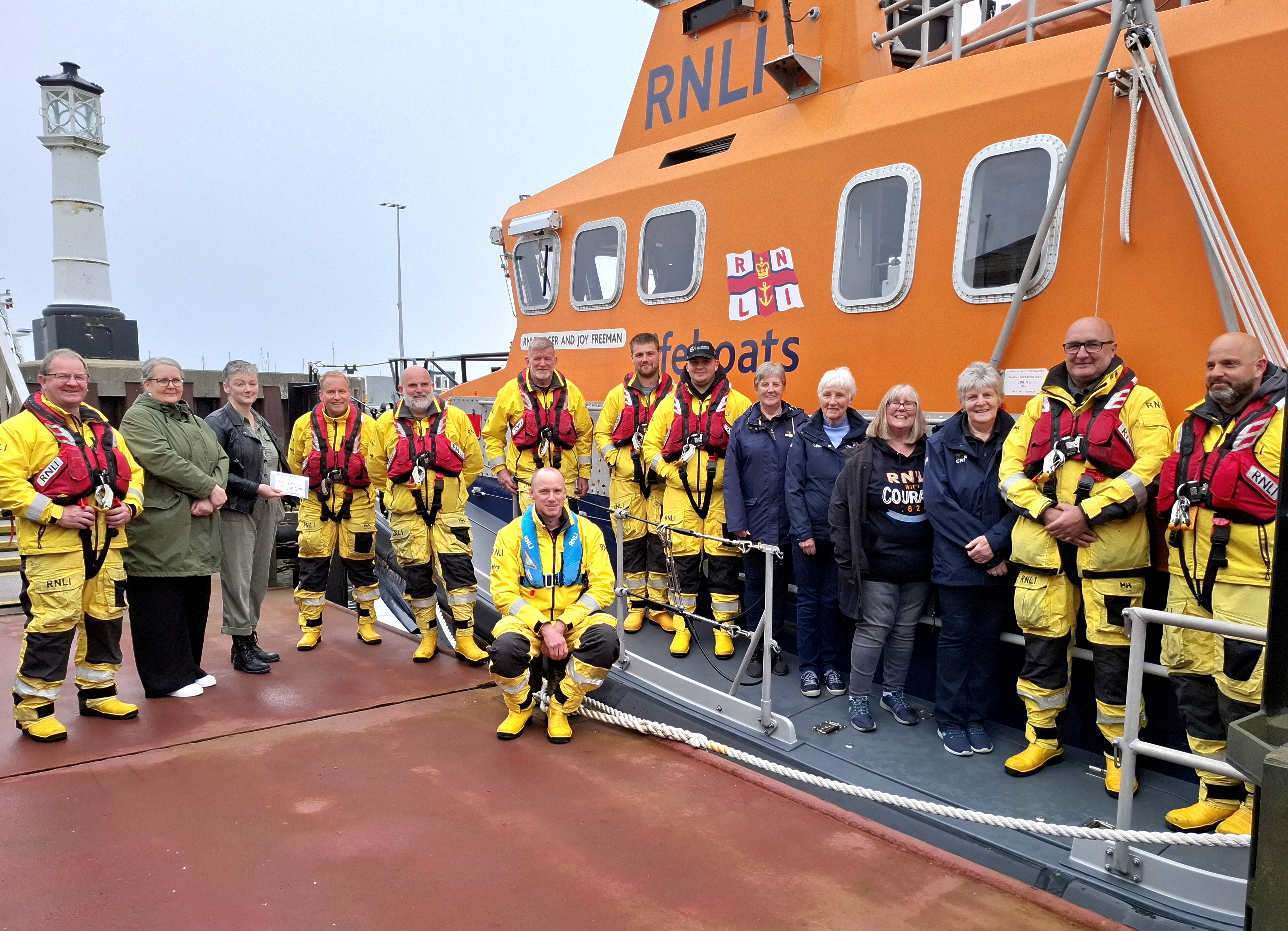 1. Volunteer boat crew and fundraising crew with Yvonne and Evie by the Roger and Joy Freeman RNLI lifeboat