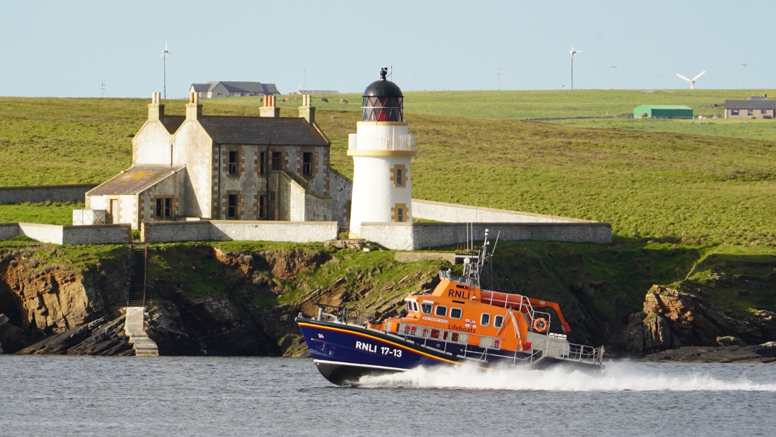 RNLI lifeboat Margaret Foster passing Helliar Holm Lighthouse at speed towards Kirkwall Harbour