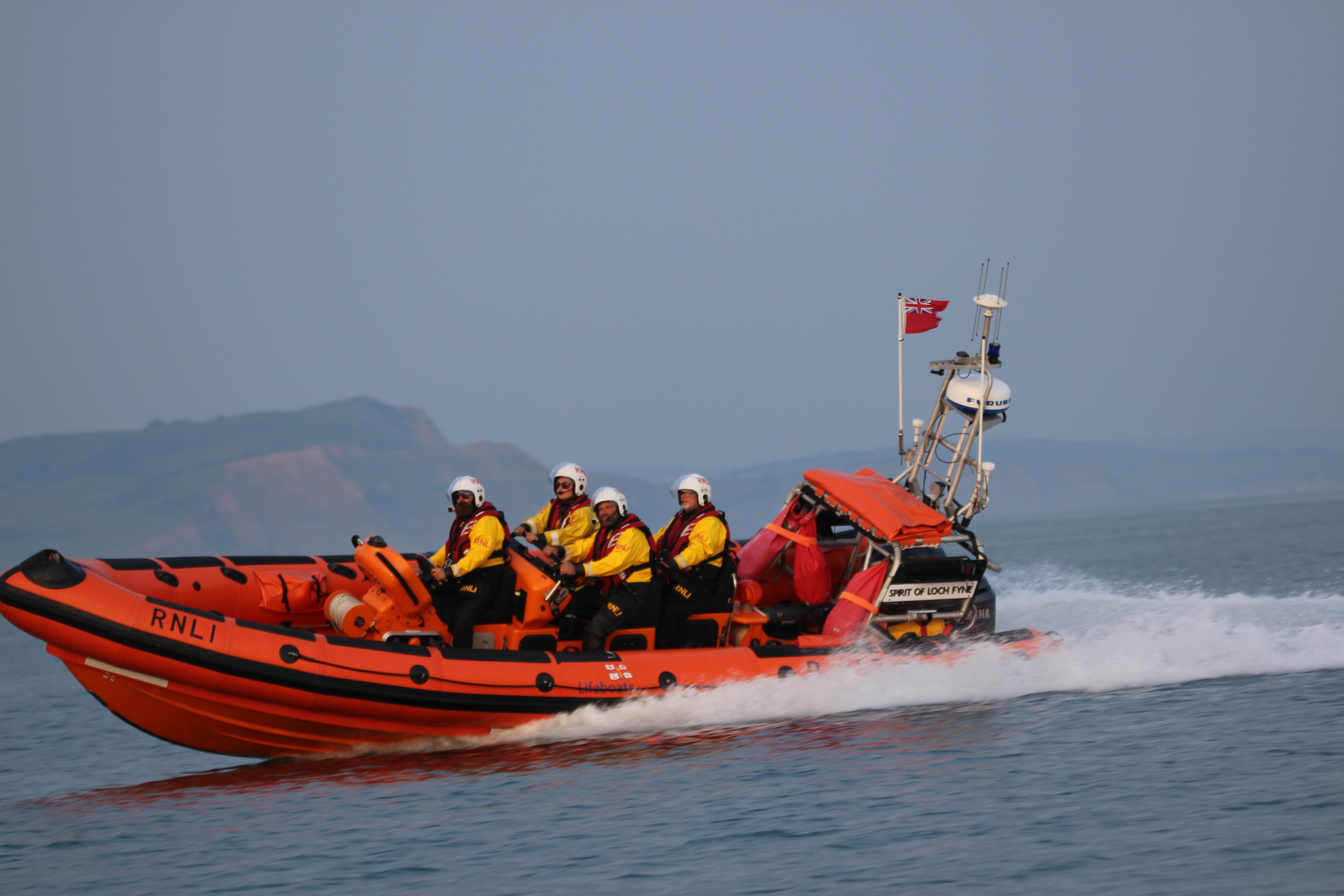 orange lifeboat moving at speed