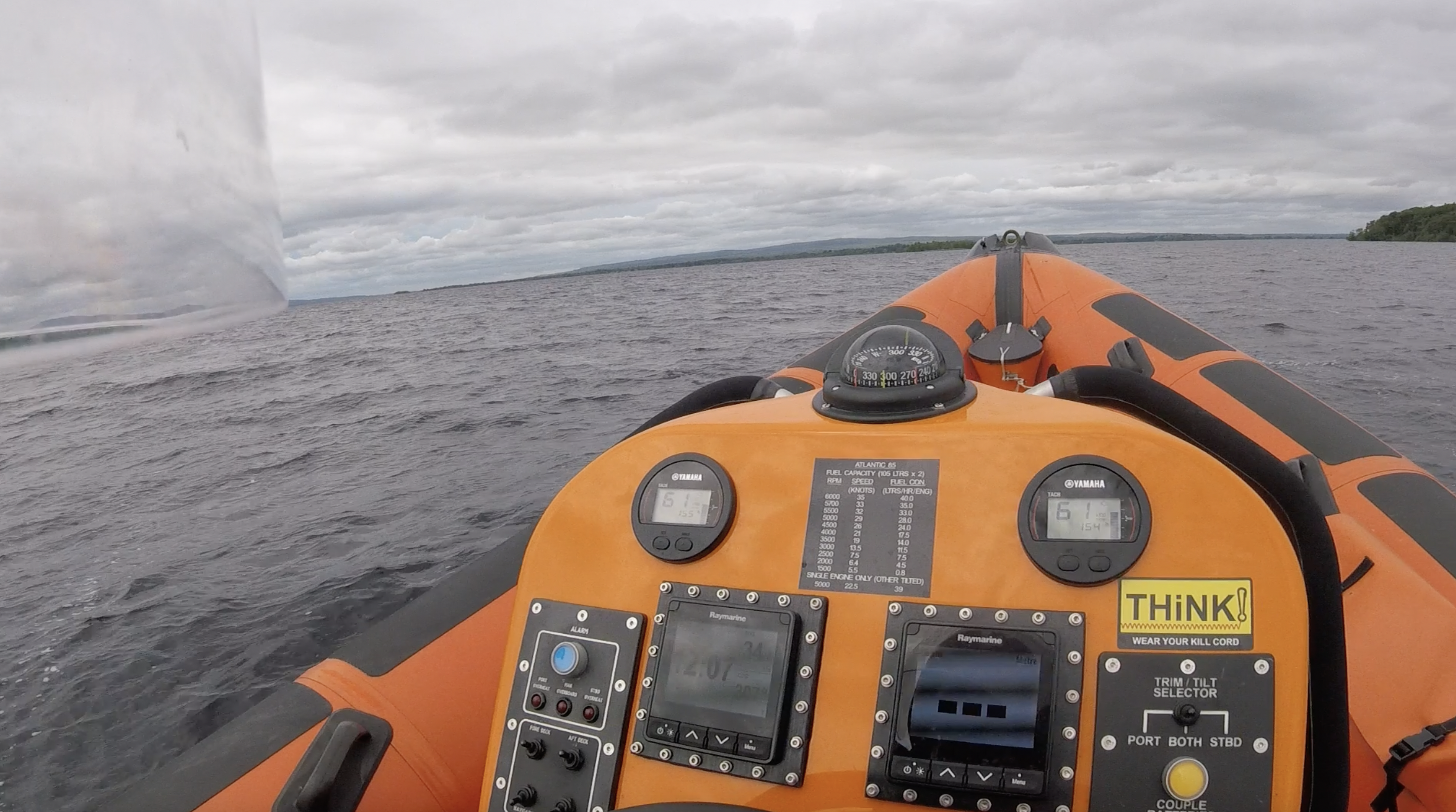 View from the helm seat, with the instrument consul and the view of the gray lake over the bow