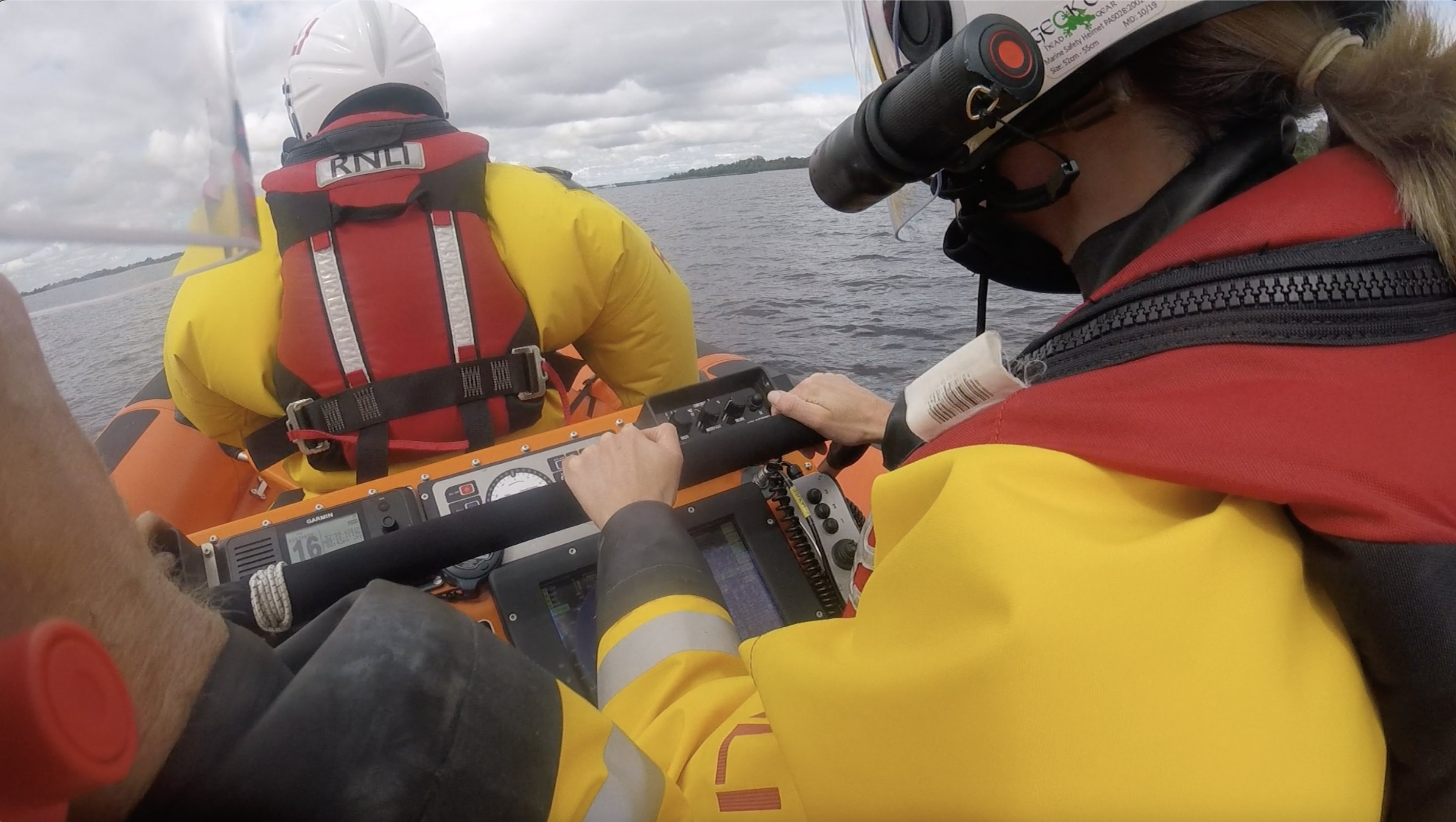 view from the helmet camera worn by the RNLI volunteer on seat 2, where the casualty vessel can be seen in the distance over the right shoulder of the volunteer in the helm sea