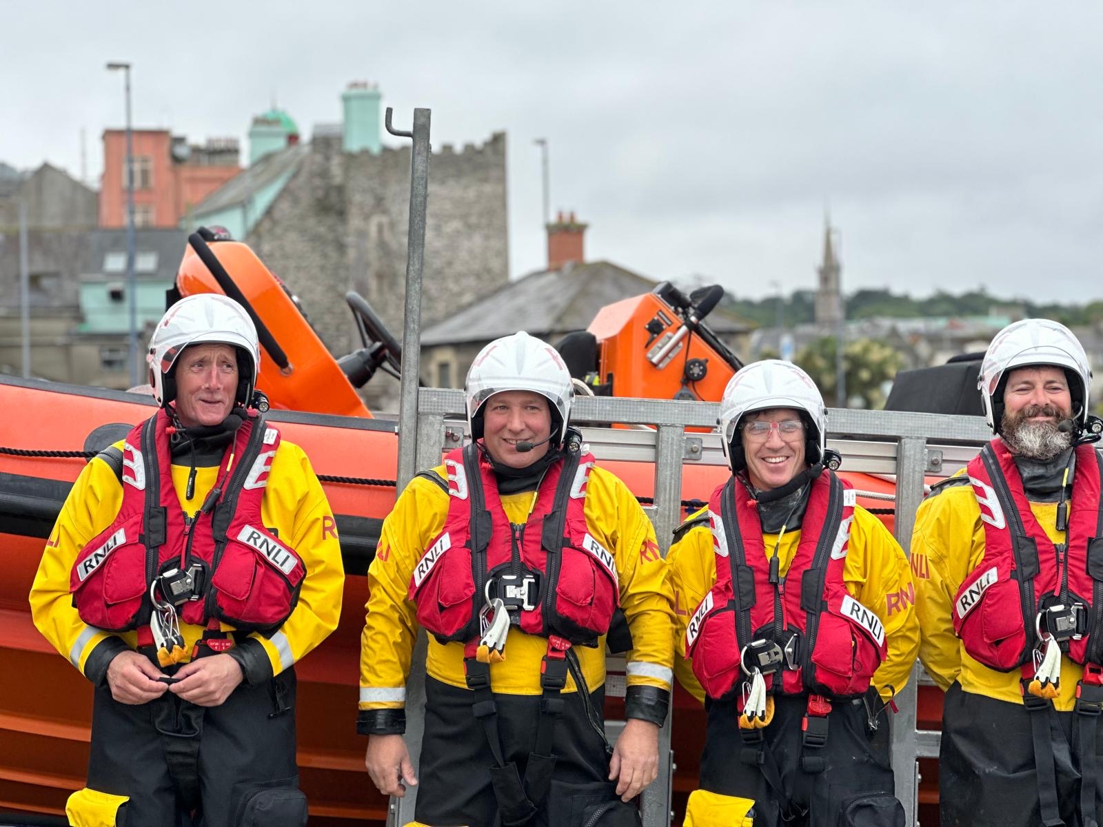 Crew standing in front of boat