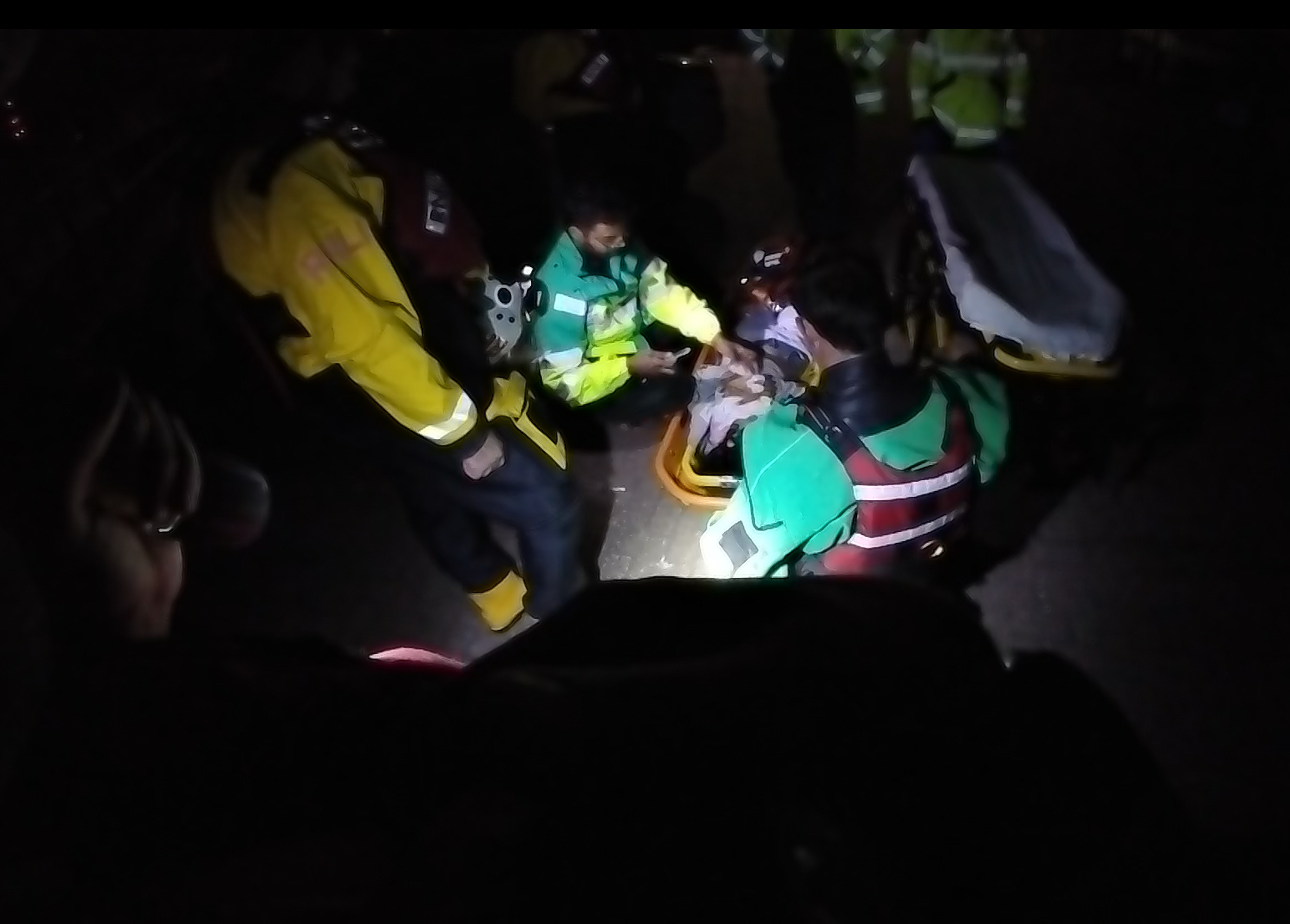 Agencies stand in the dark around the casualty 