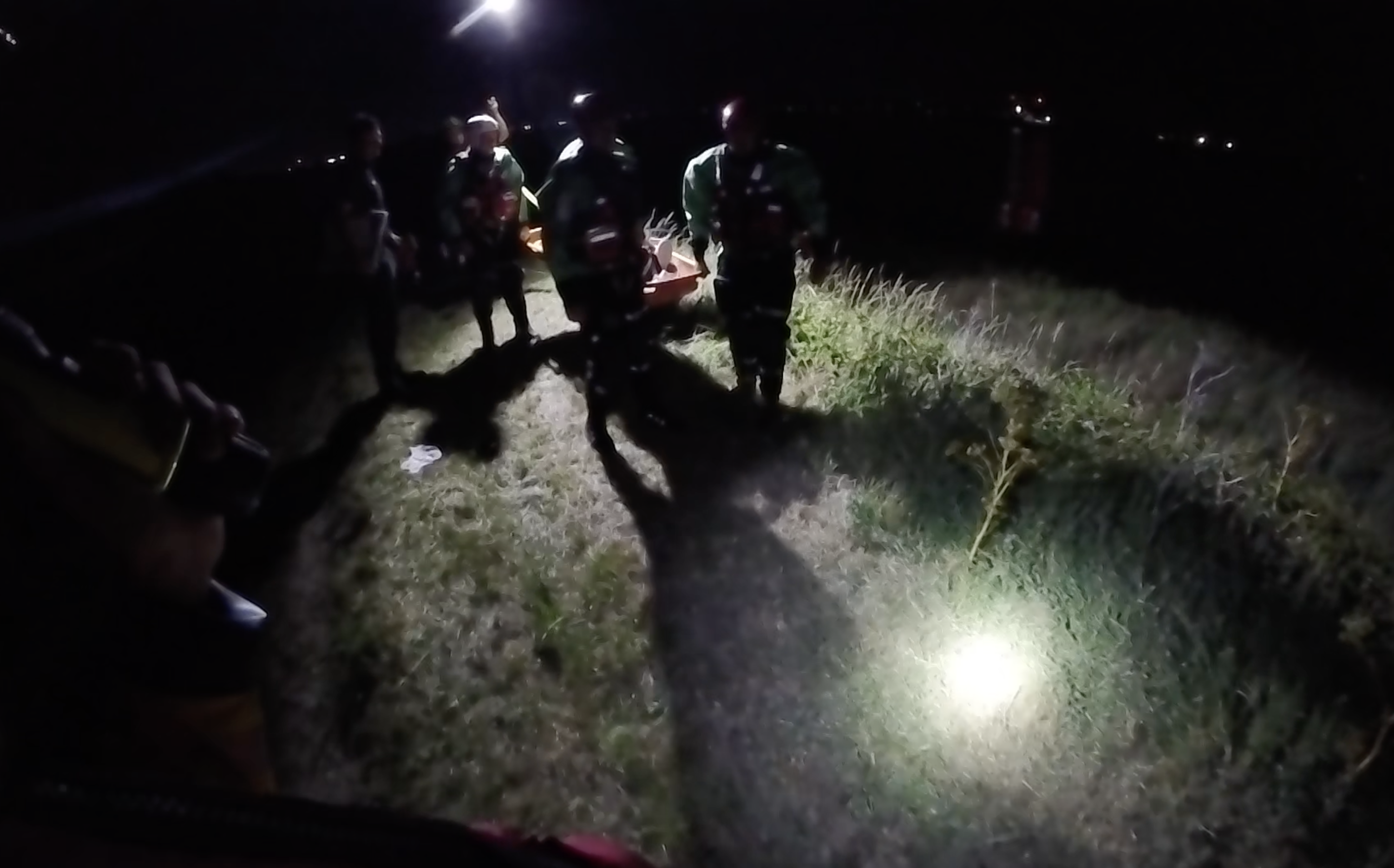 Crews walk the casualty away from the grass down onto foreshore before getting onto lifeboat