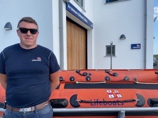 Tom Davis, Arranmore RNLI Coxswain on the call out pictured in front of an inshore lifeboat
