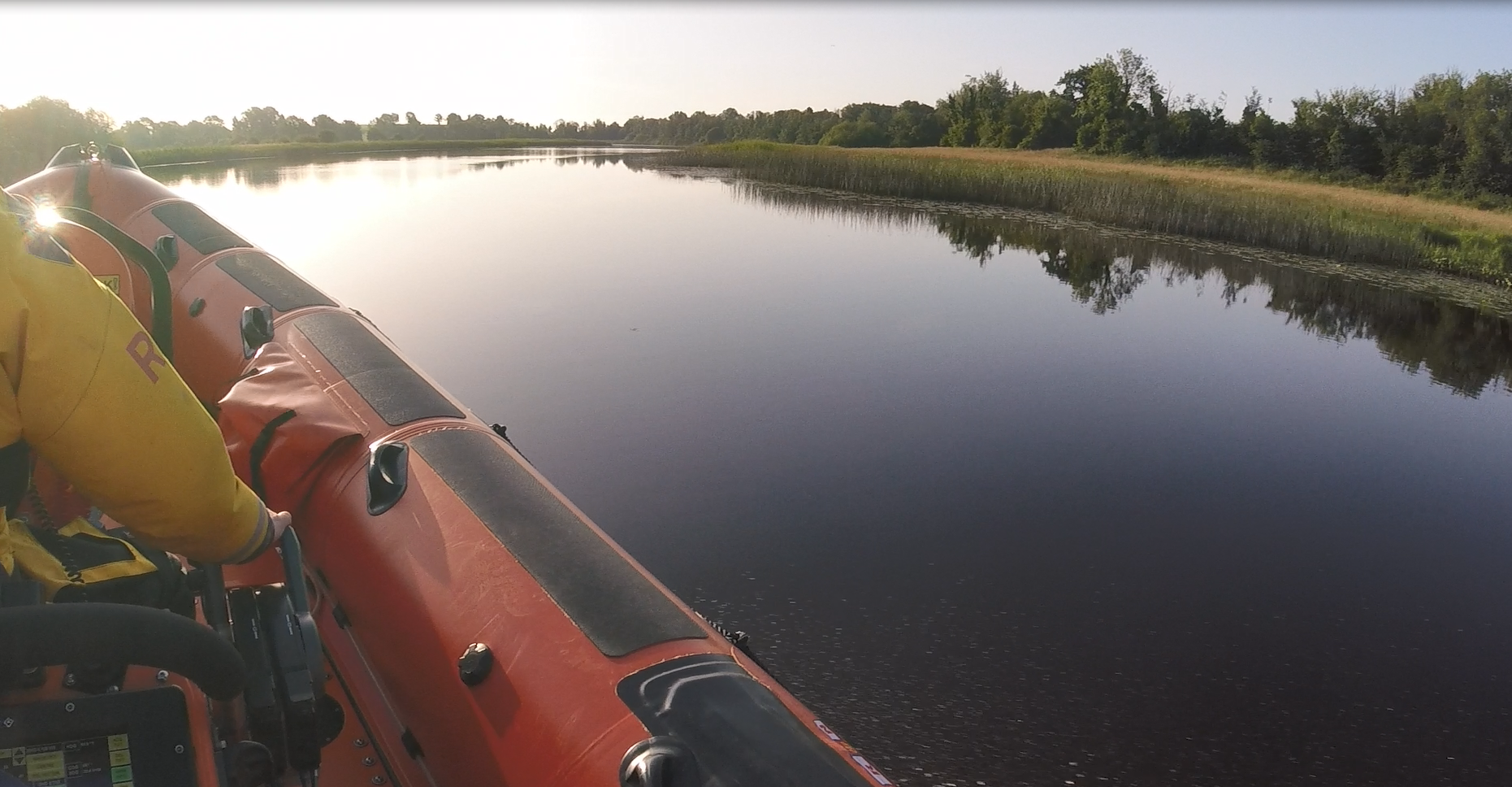 Carrybridge Lifeboat proceeding to locate a EPIRB on a bright sunning morning. Crew member helming the lifeboat.