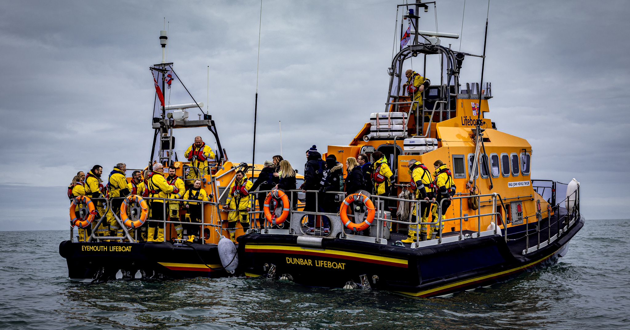 Two lifeboats with people on board.