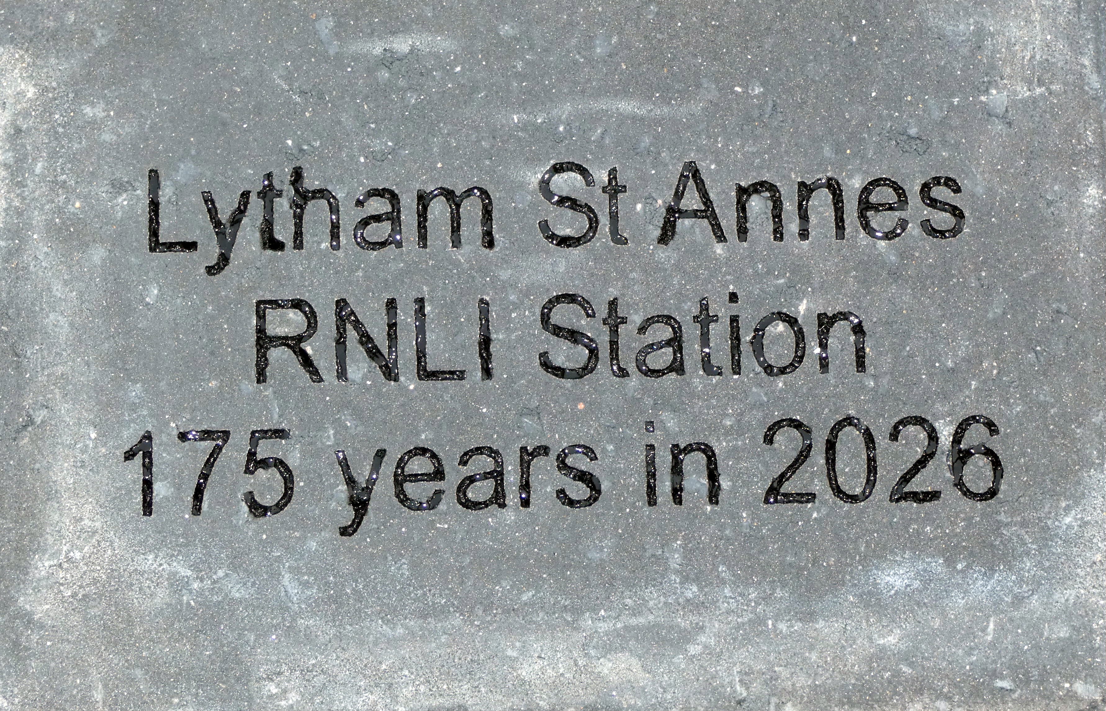 A paver with an inscription etched on it