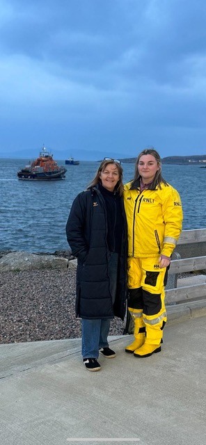 Arranmore Trainee crew member Aine Boyle with her mother Elaine standing on the pier with the lifeboat on the water in the background.