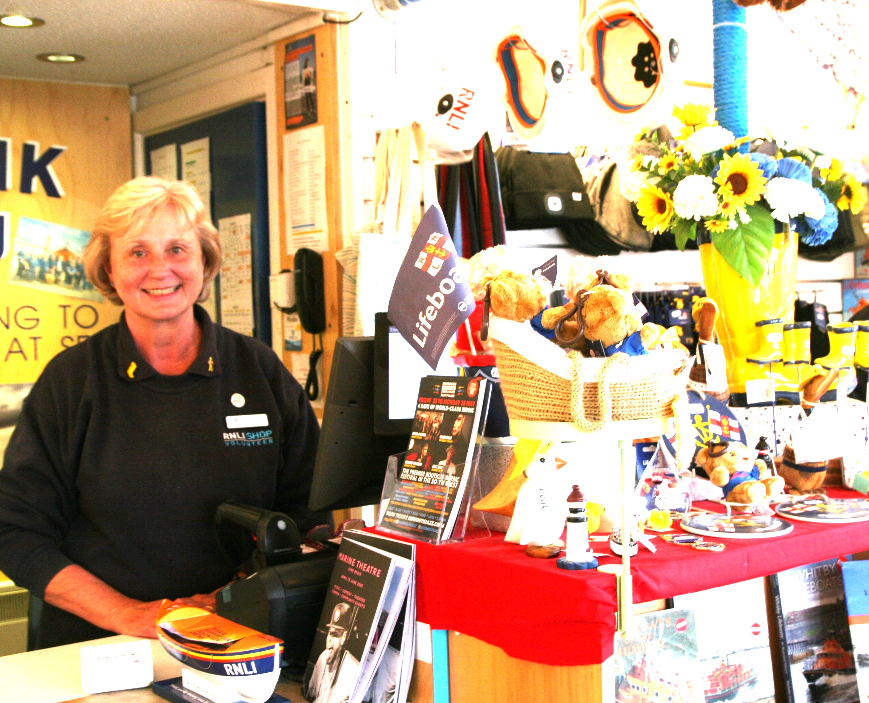 Woman in blue top in shop with display
