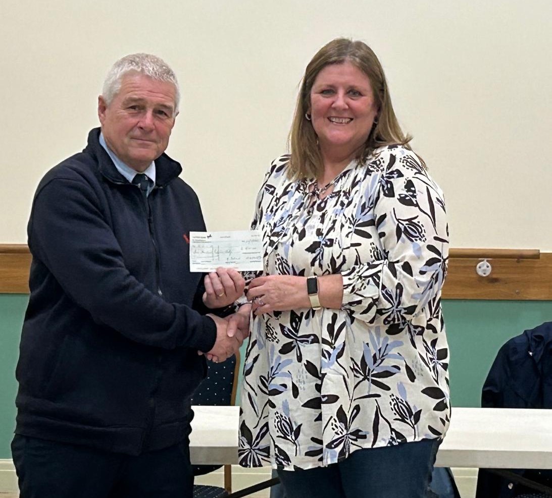 The image shows Tricia Davies presenting the £500 cheque to Clive Morris following the talk.