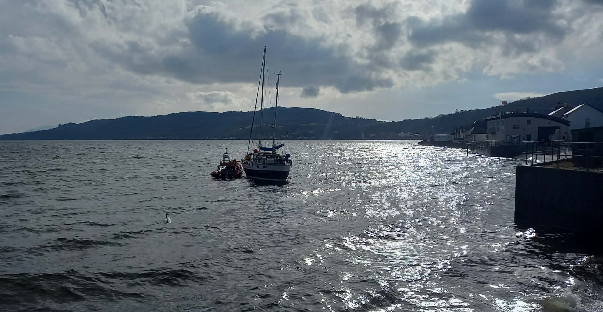 The inshore lifeboat is alongside the casualty vessel just by the RNLI station