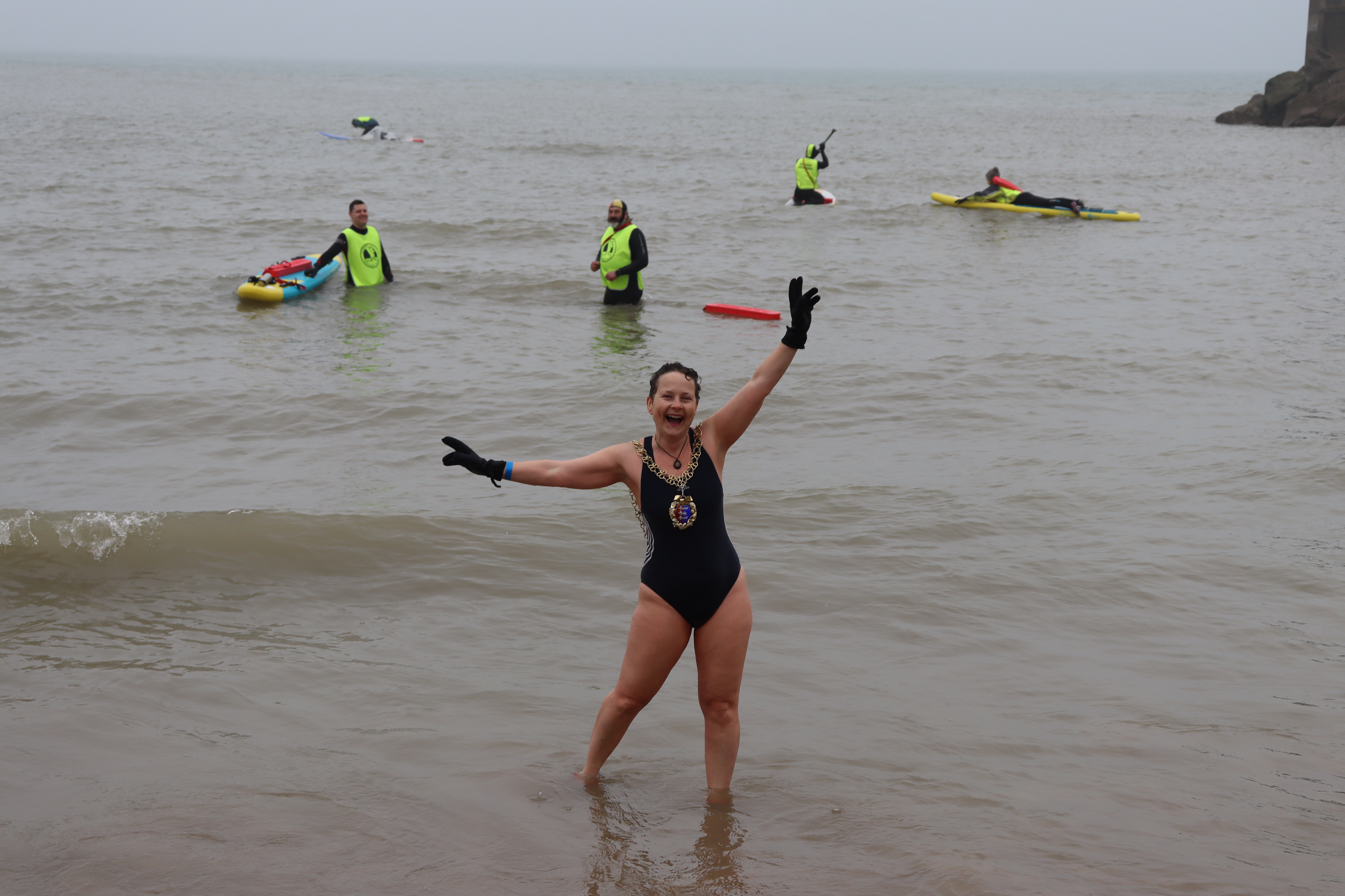 The mayor of Hastings, Cllr Becca Horn, joining in the dip, complete with mayoral chain, watched by Hastings Voluntary Lifeguards