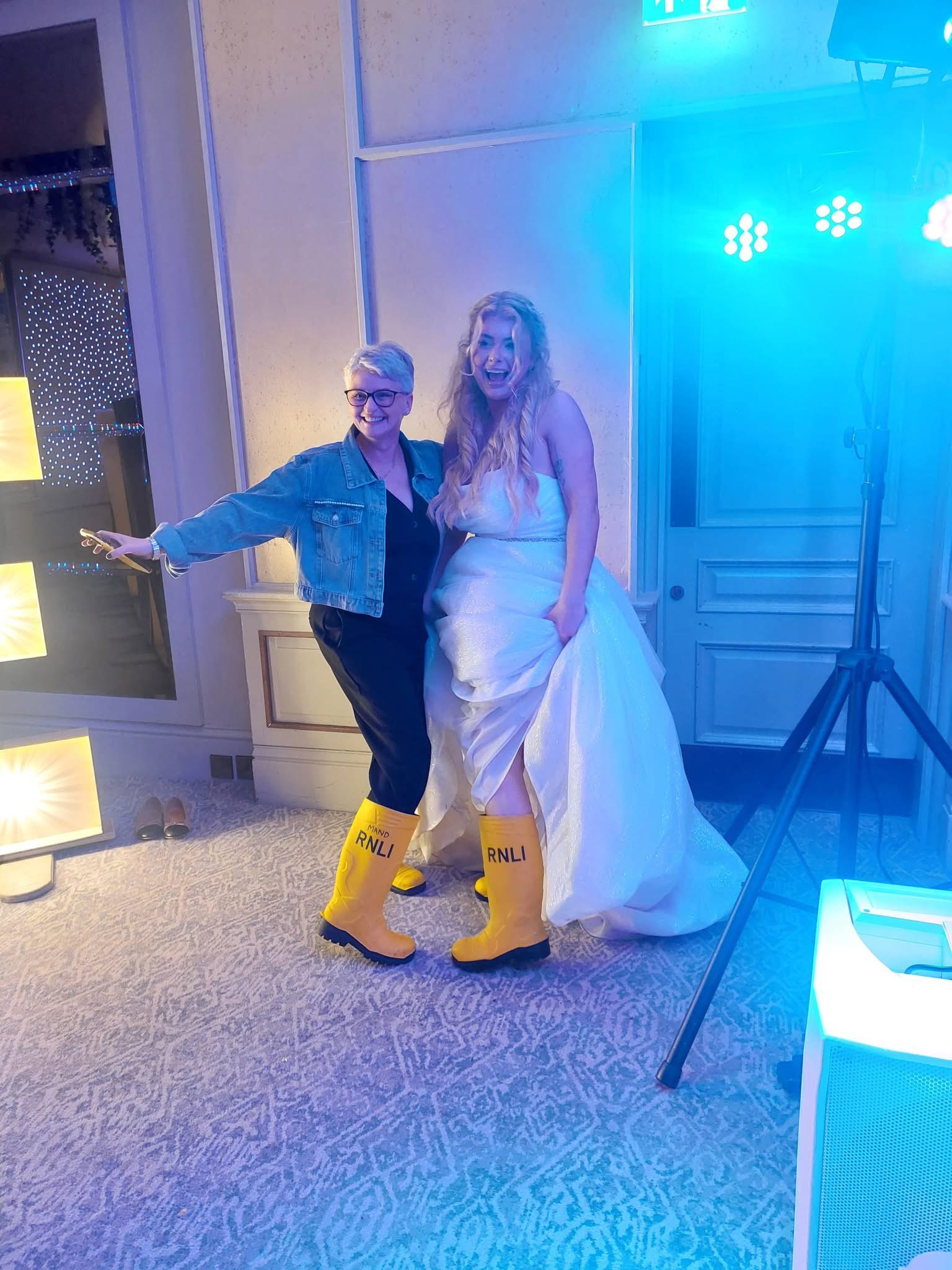 Portrait image of Lauren and Amanda at an event where both are wearing RNLI wellies.
