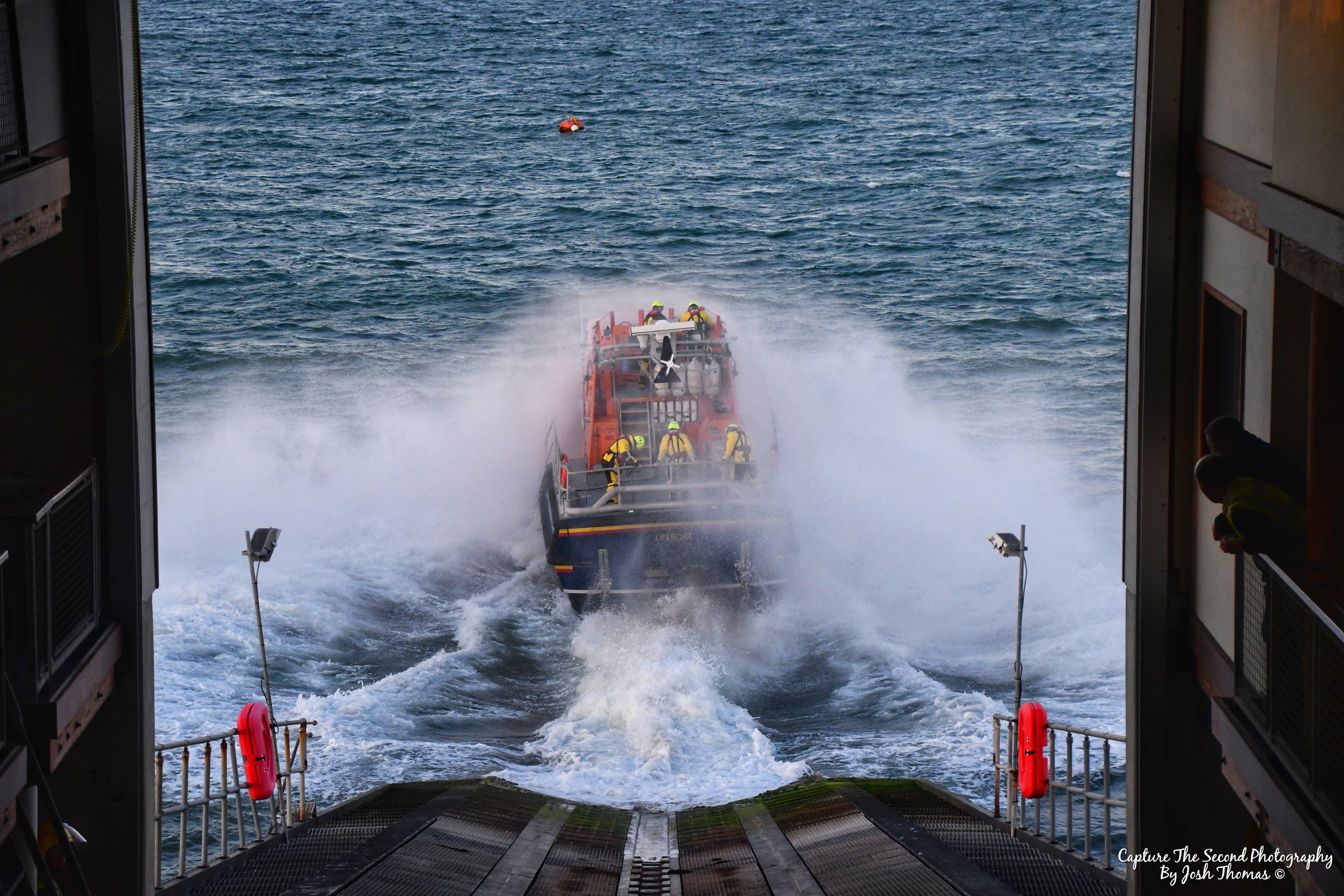 Alfred Albert Williams Tamar class all weather lifeboat launching, water spraying as it hits the water from slipway
