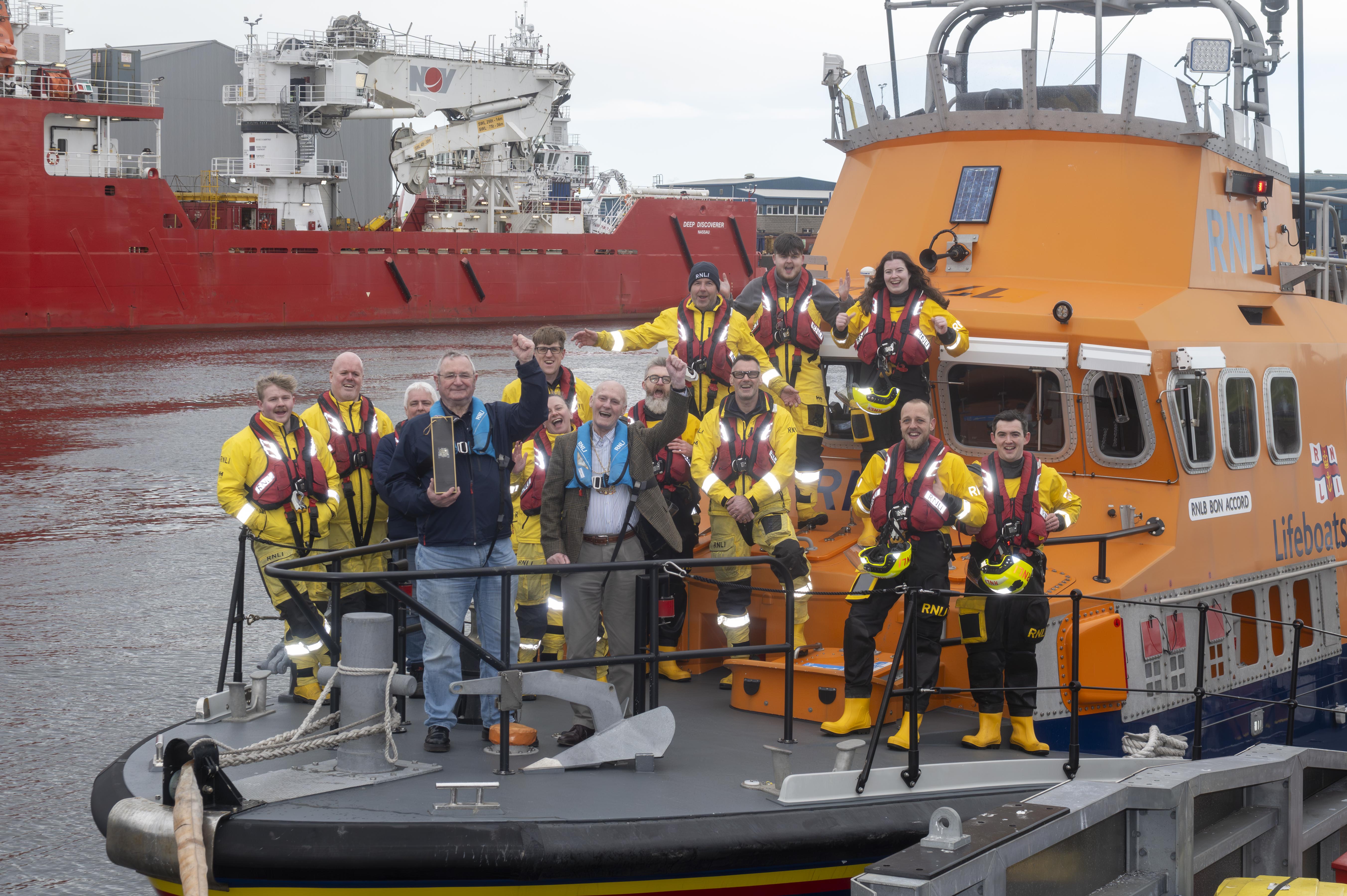 Group of people posing for photograph aboard all-weather lifeboat, Bon Accord, including Bill Deans, Lord Provost and crew members