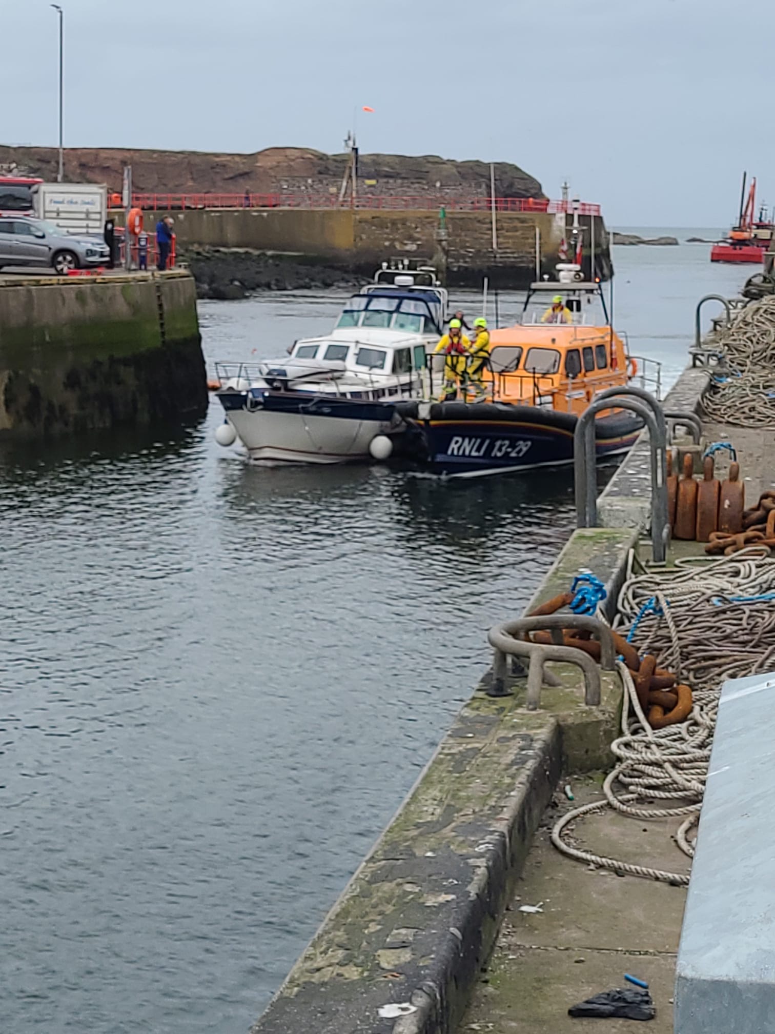 Eyemouth RNLI crew tow a motor cruiser that had suffered engine failure NE of St Abbs Head. Pictured is the lifeboat towing the casualty vessel alongside it into Eyemouth harbour.