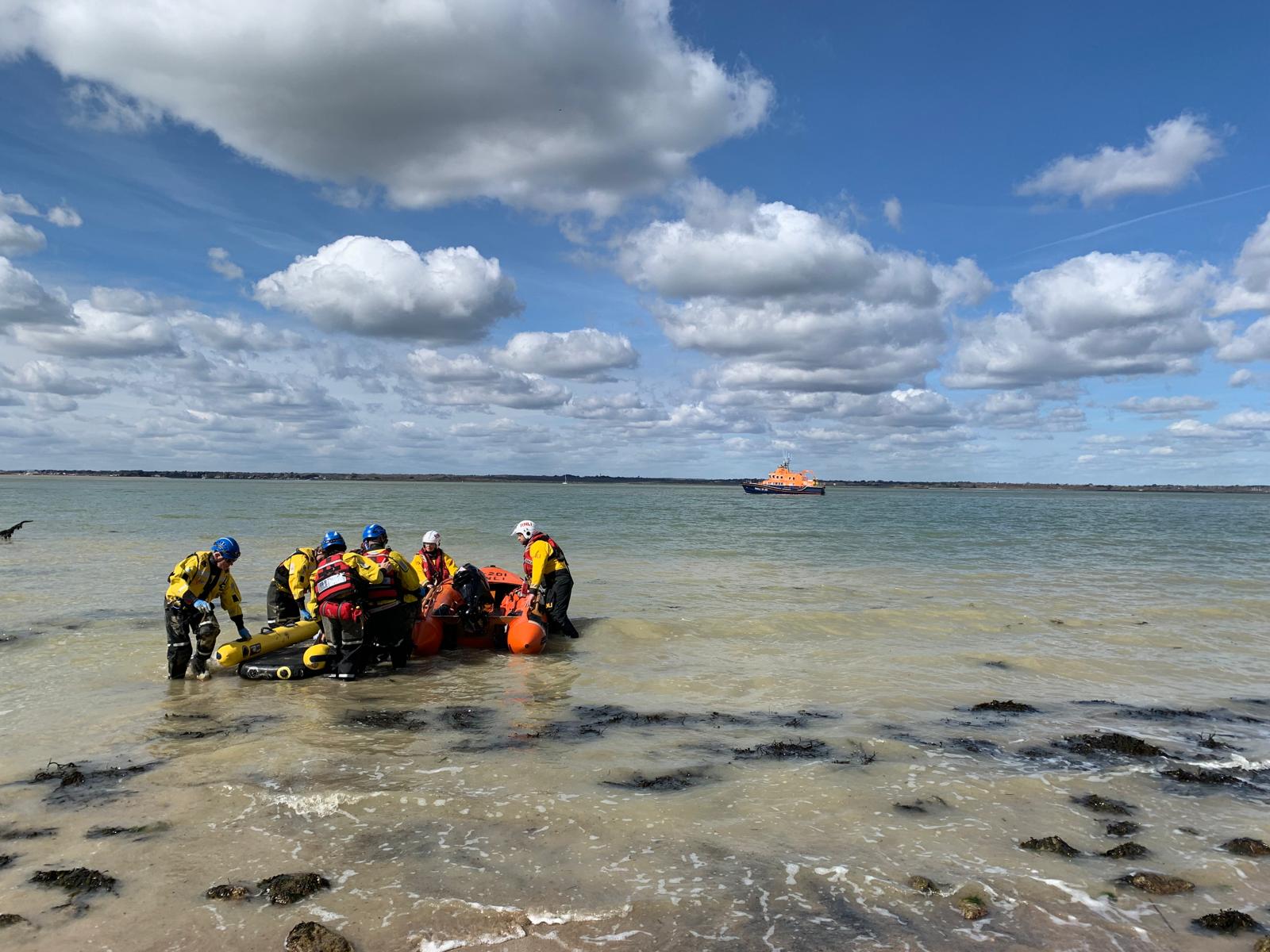 Yarmouth RNLI and the Coastal Rescue Team working together to transfer the casualty to the Yboat