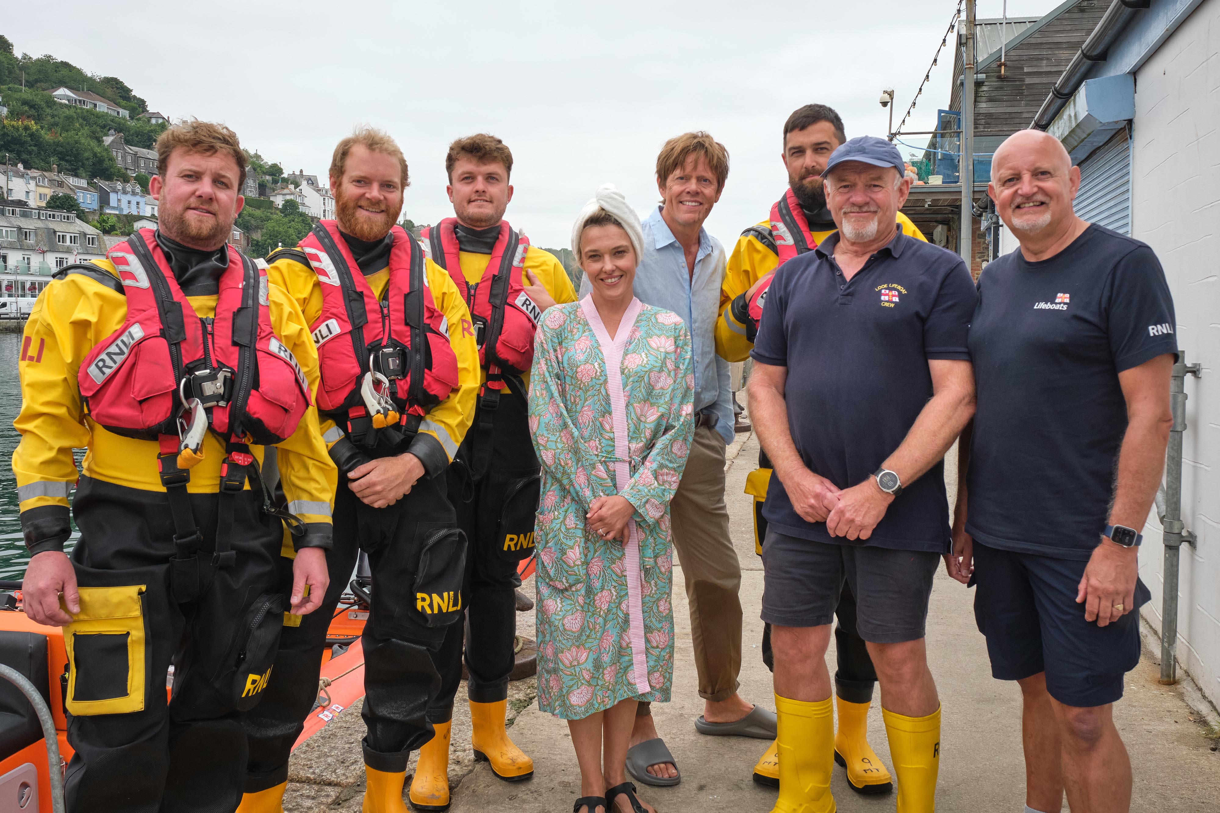 Looe RNLI volunteer crew with Humphrey and Martha Goodman on East Looe quay Left to right Jack, Nathaniel, Alex, Sally Bretton, Kris Marshall, Mark, Simon and Adam
