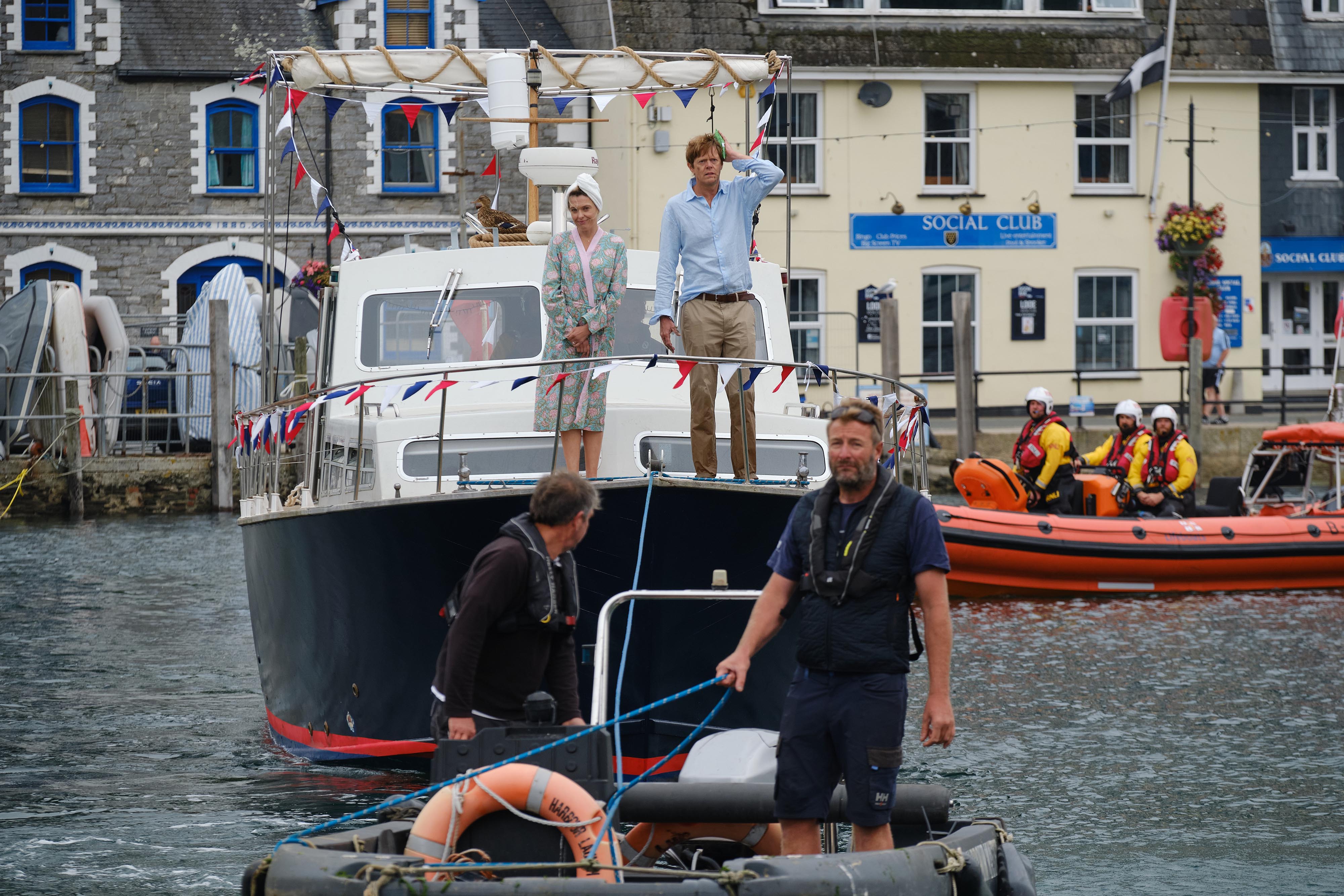 Looe harbour team bringing Humphrey and Martha on the houseboat Lily Bond alongside East Looe quay