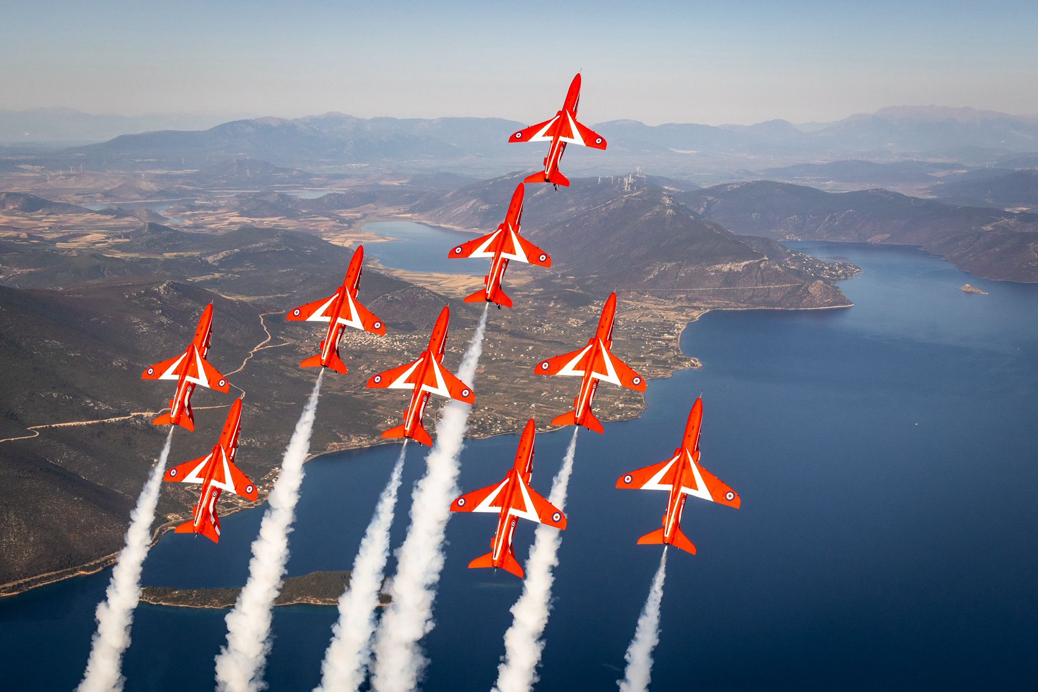Nine red jet aircraft rising in the sky