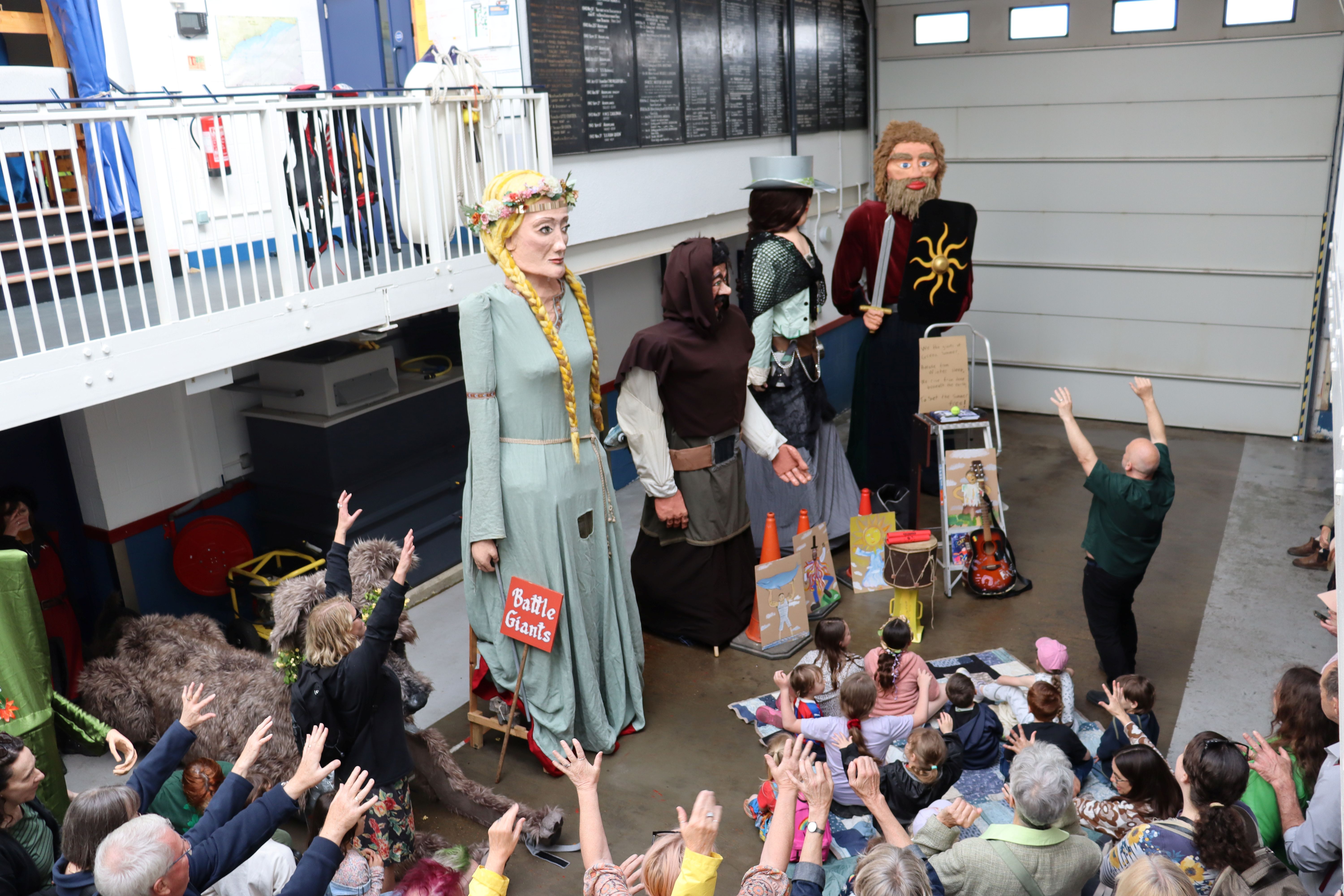 Ed Boxall and the audience wave their hands at the giants