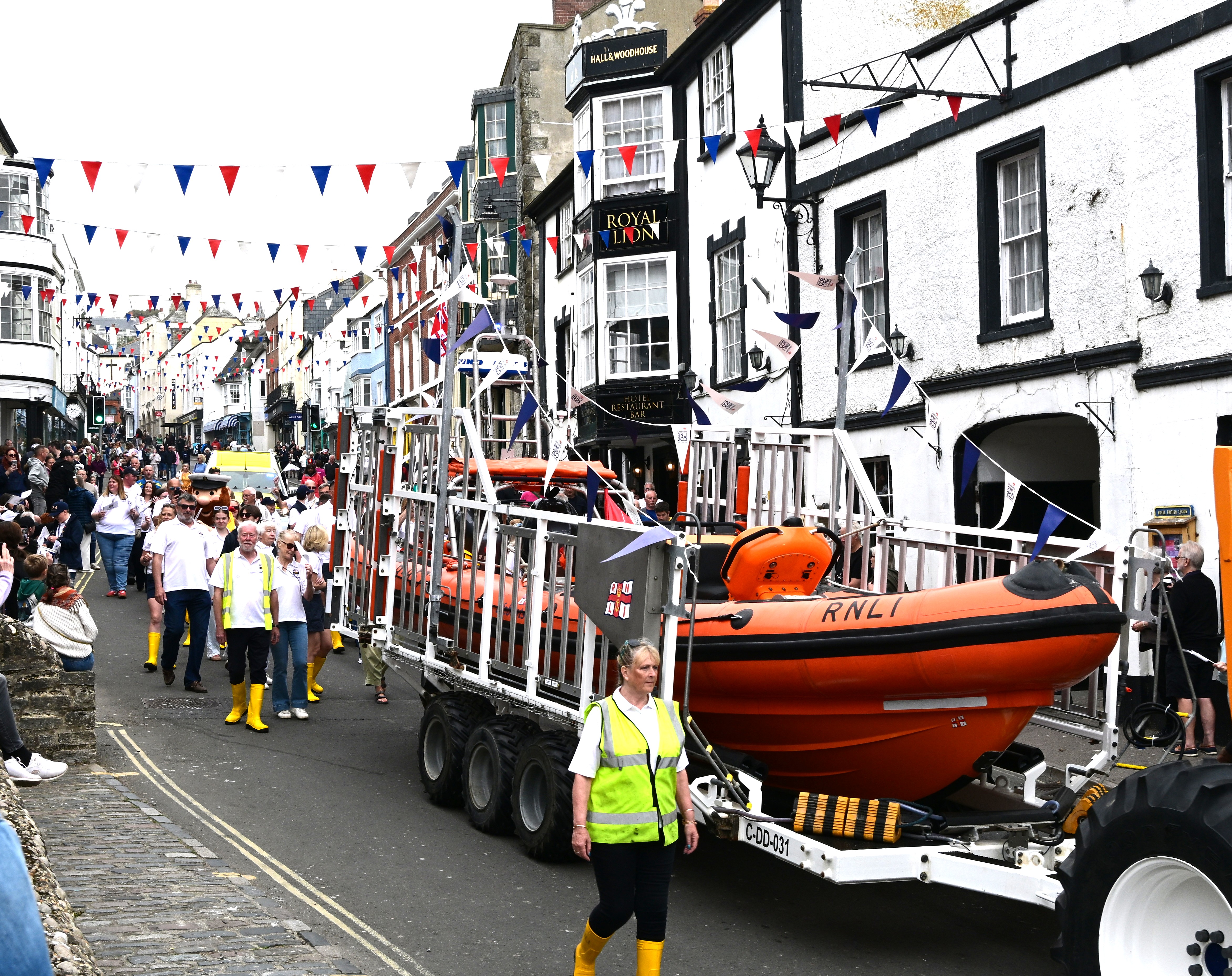 Orange lifeboat passing crowds of people