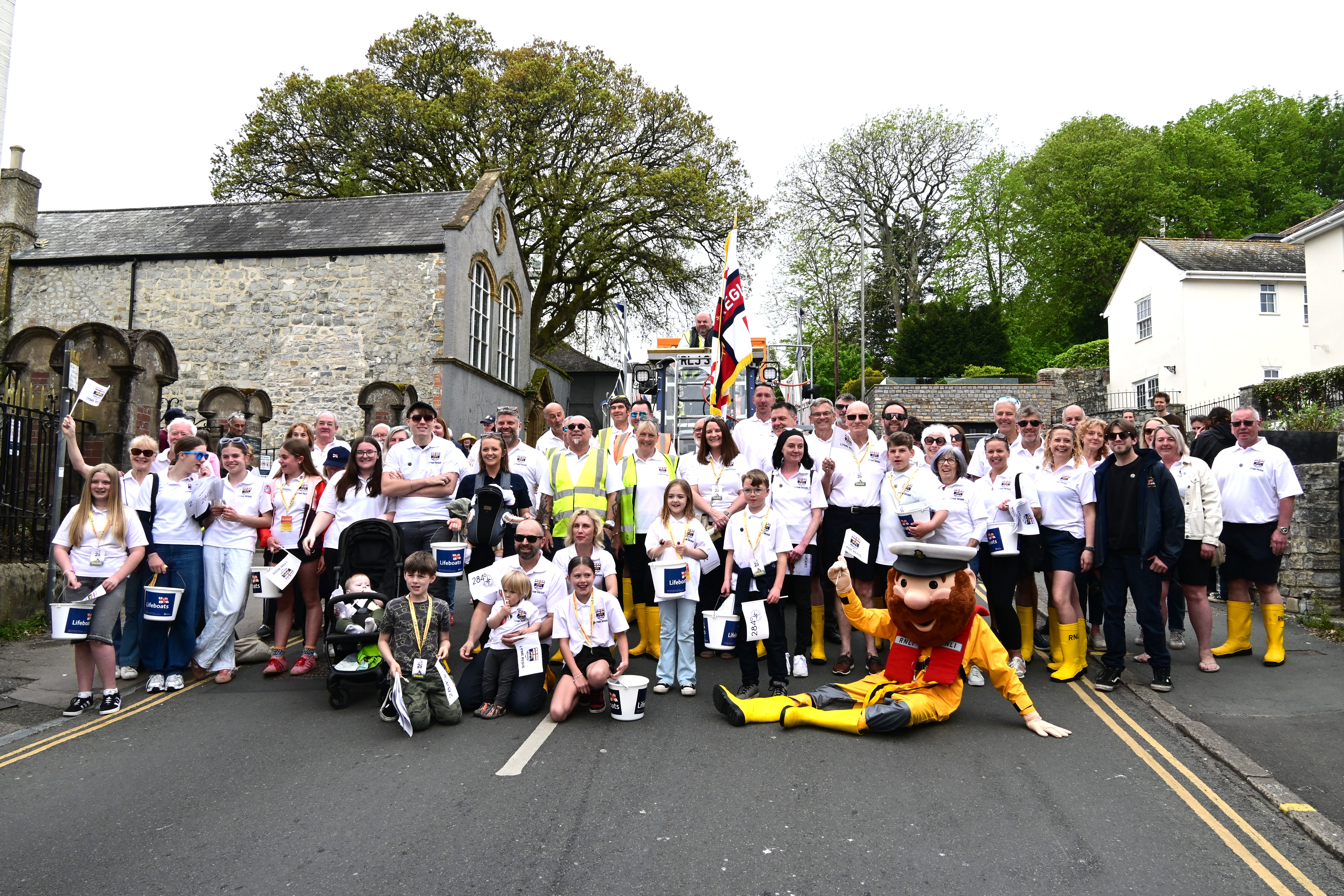 Group of people in white tops in front of lifeboat