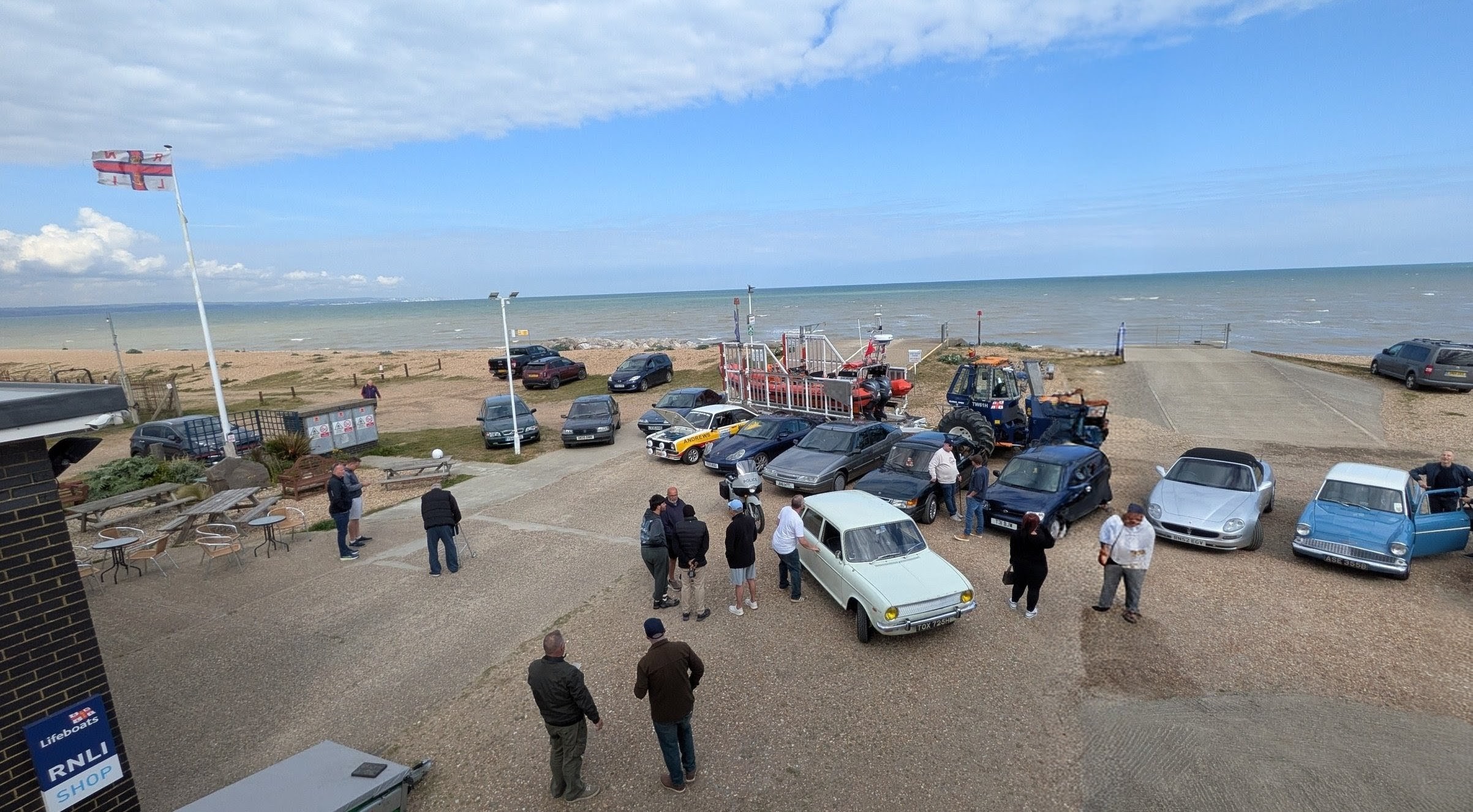 A varied group of retro cars spread out in front of the Orange Litlestone RNLI lifeboat Jean McIvor