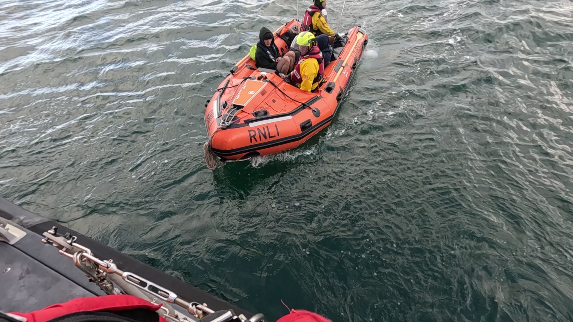 Torbay's D-class Inshore lifeboat approaching the Severn-class All-Weather lifeboat with casualties onboard