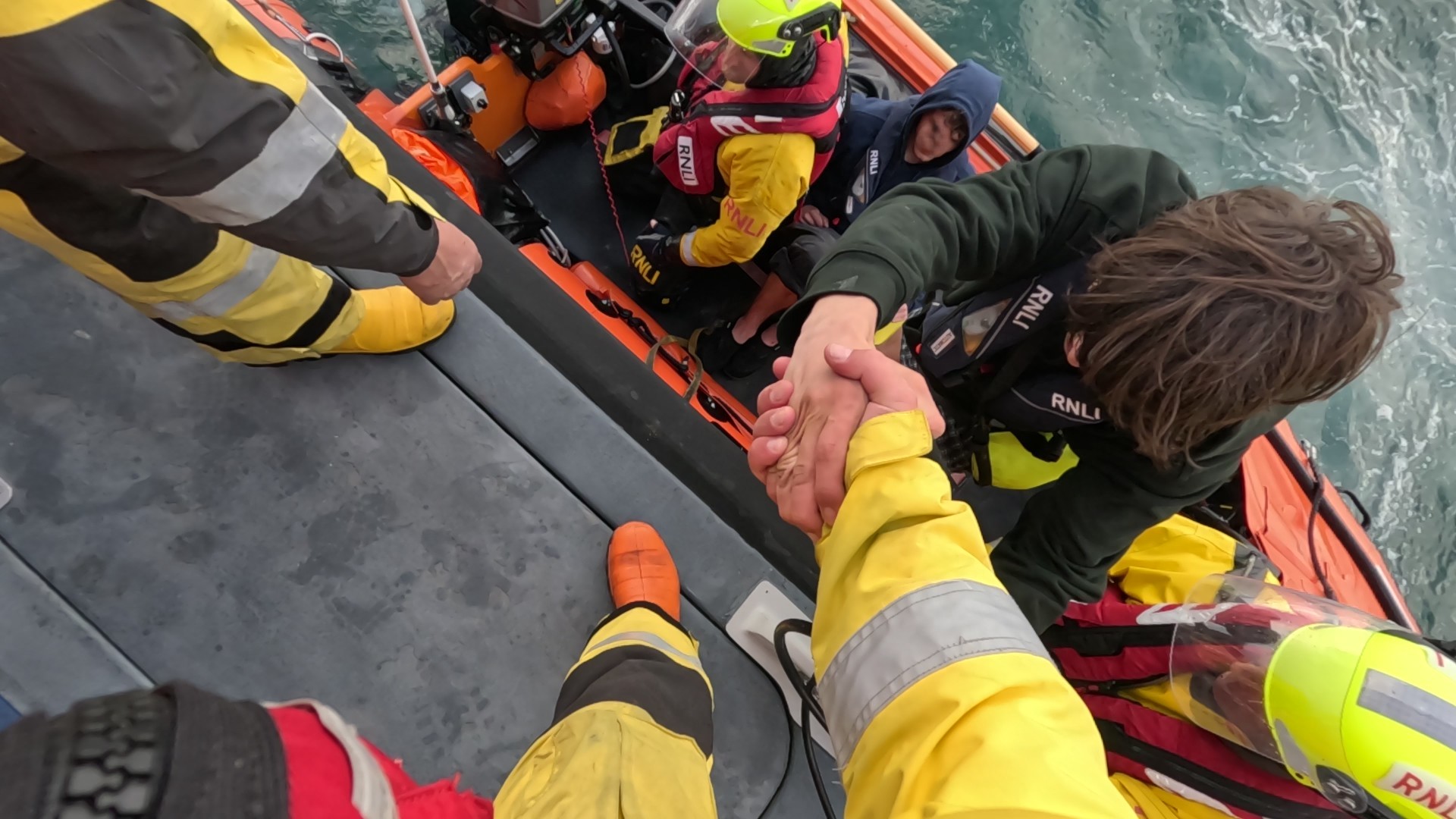 Casualties being brought onto Torbay's All-Weather lifeboat by the volunteer crew
