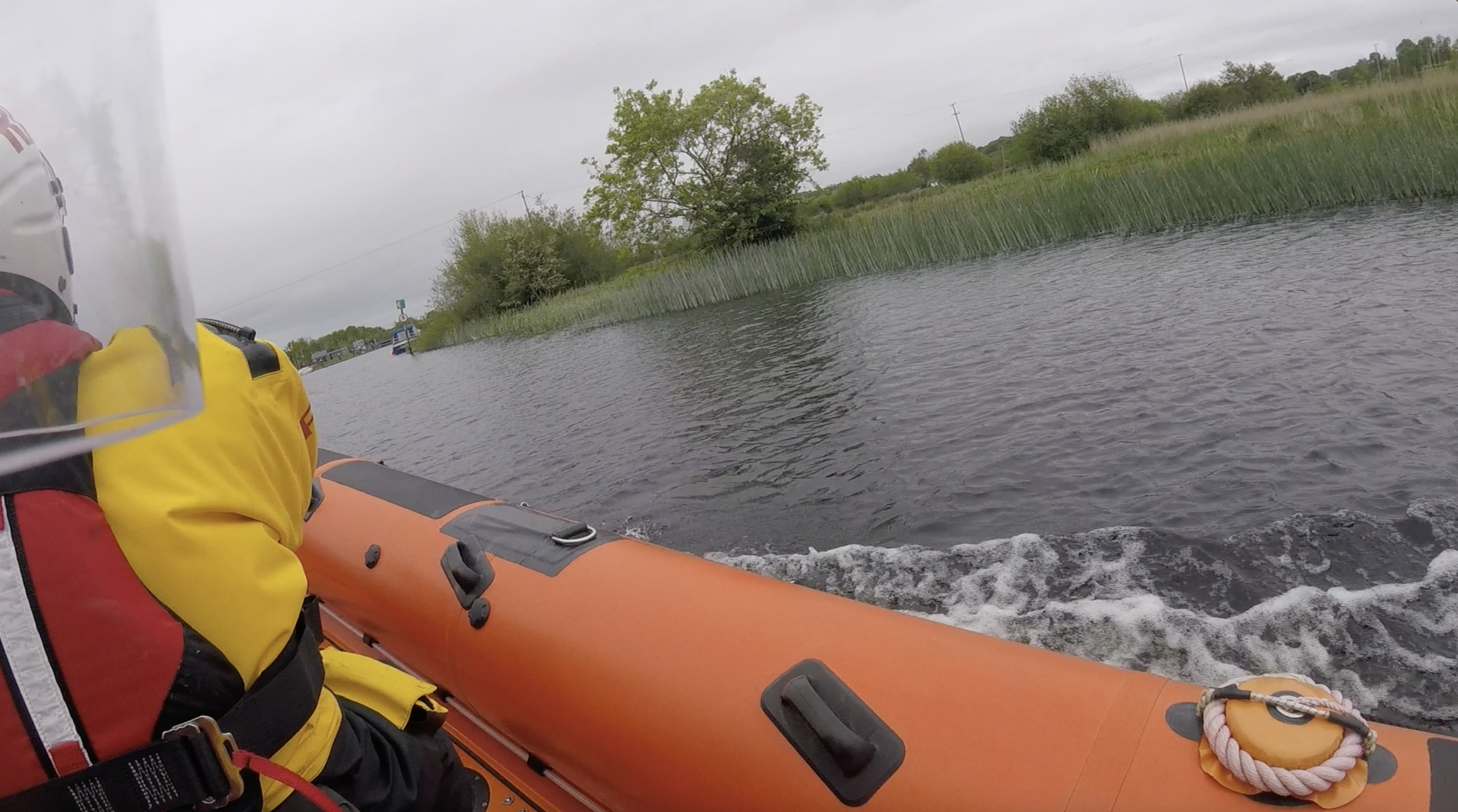 view over the right shoulder of crew on seat 3 of Portumna Bridge over bow and the narrow river and grassy shore, starboard side