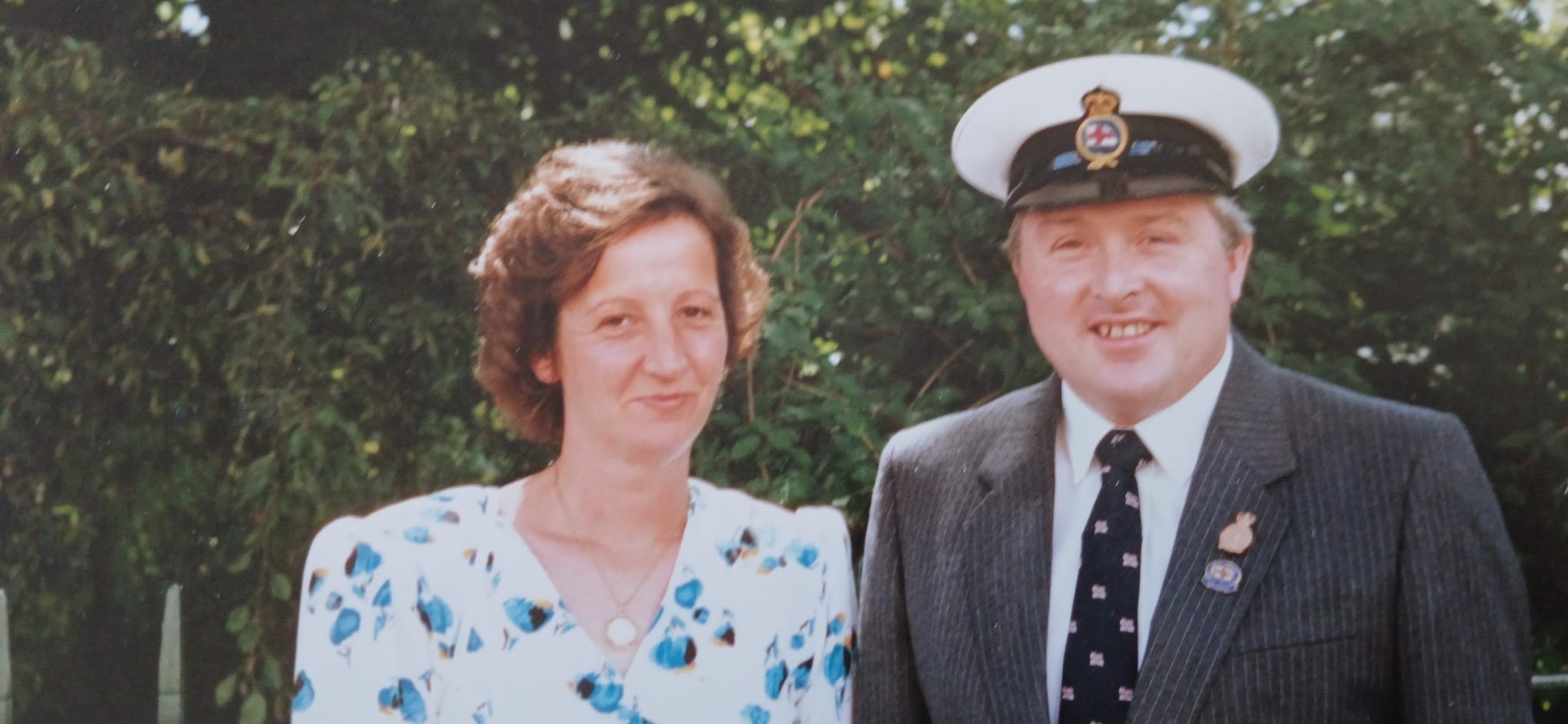 landscape image of Ron and his wife Brenda with a backdrop of greenery