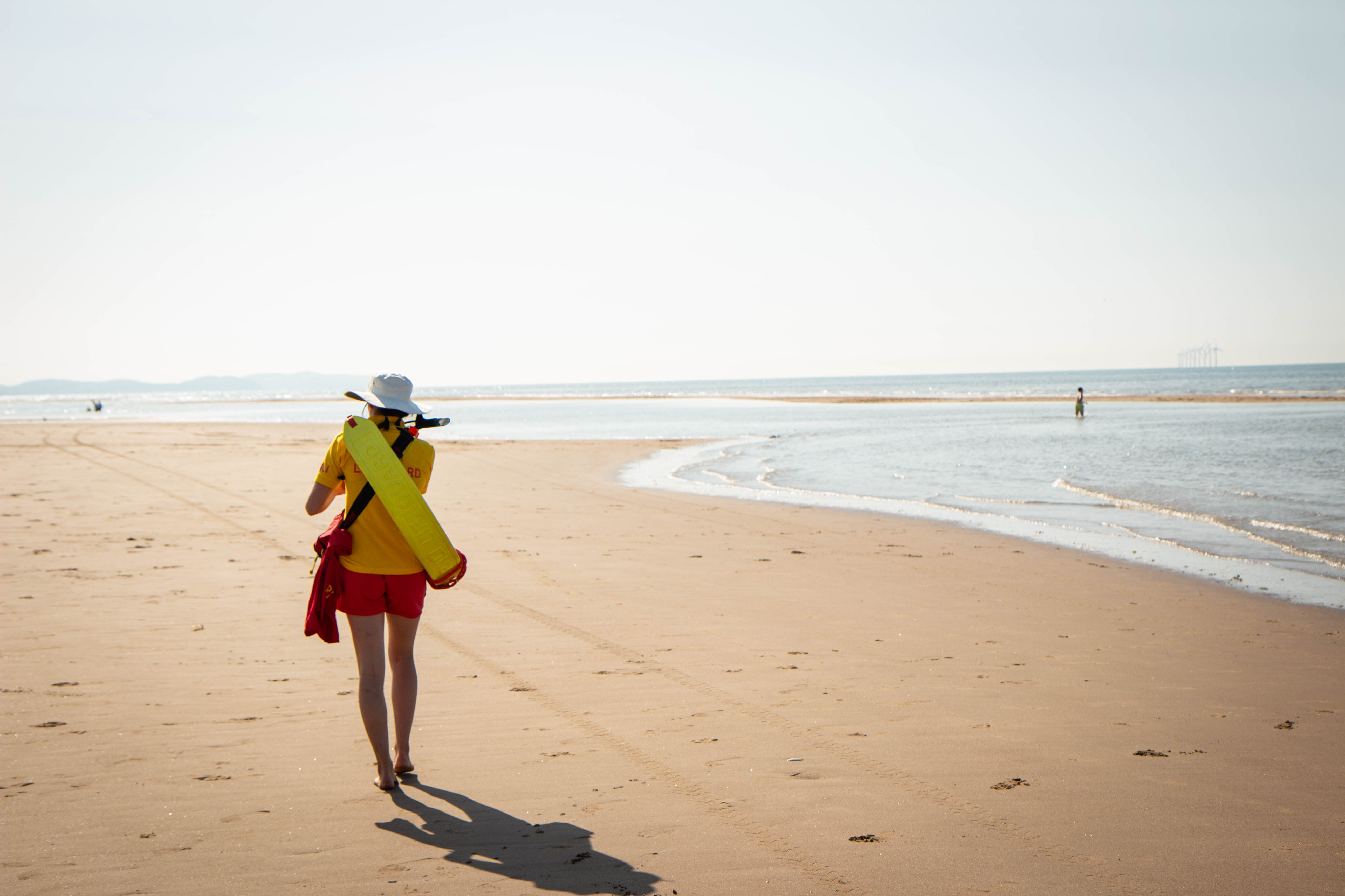 Landscape image of RNLI beach lifeguard patrolling on the beach 