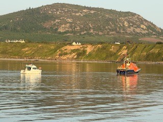 Porthdinllaen Lifeboat pictured with vessel in tow entering Porthdinllaen Harbou