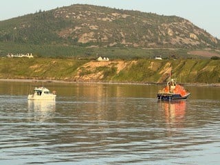 Porthdinllaen Lifeboat pictured with vessel in tow entering Porthdinllaen Harbou