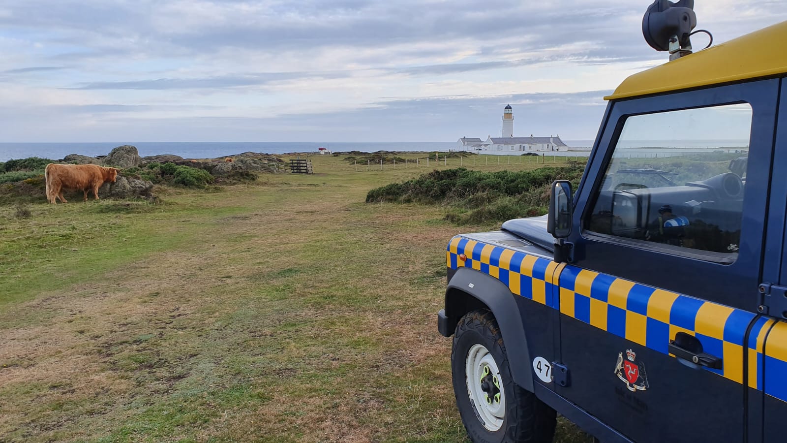 A picture of a blue Coastguard vehicle with Langness lighthouse in distance